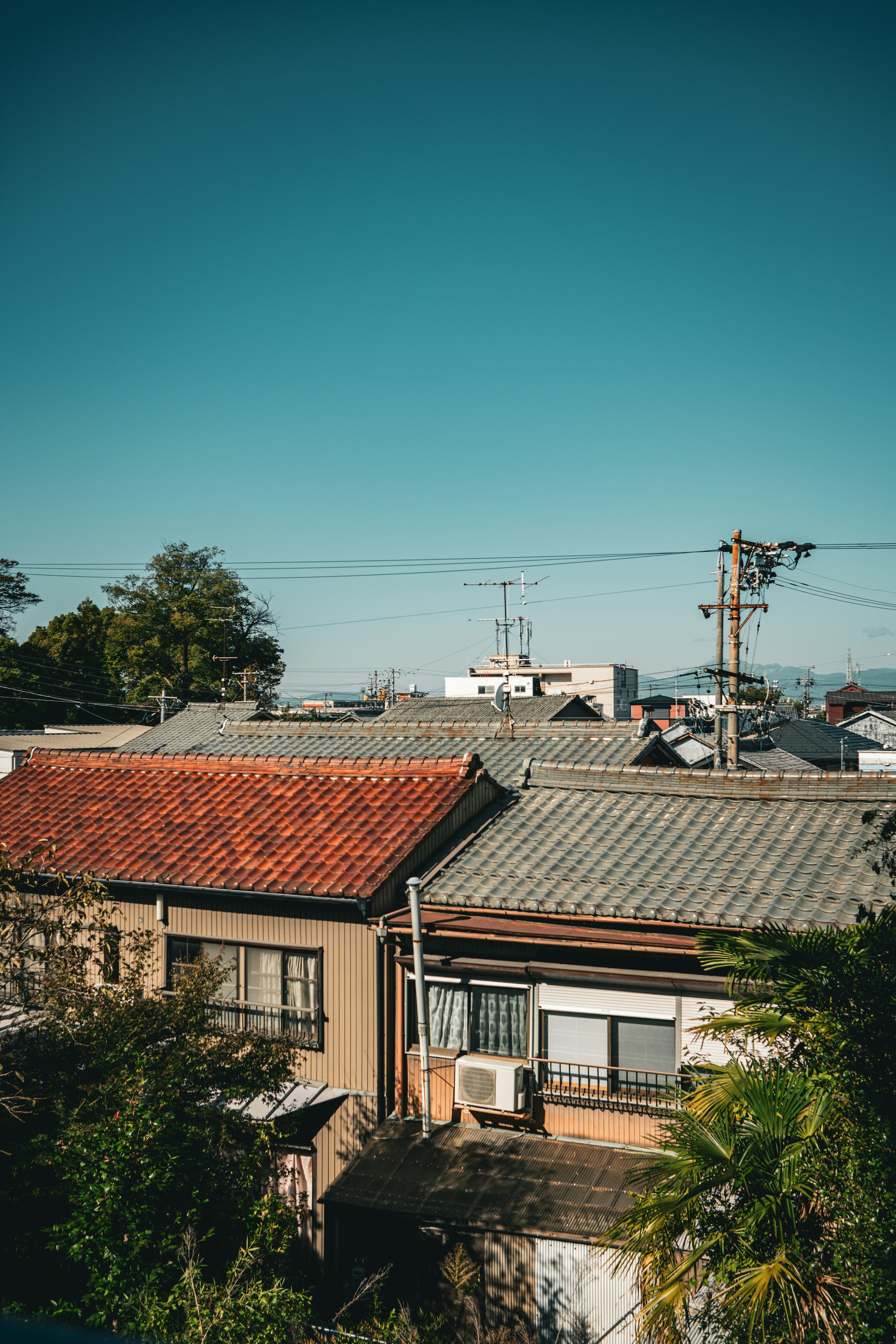 青空の下にある和風の住宅と屋根の風景