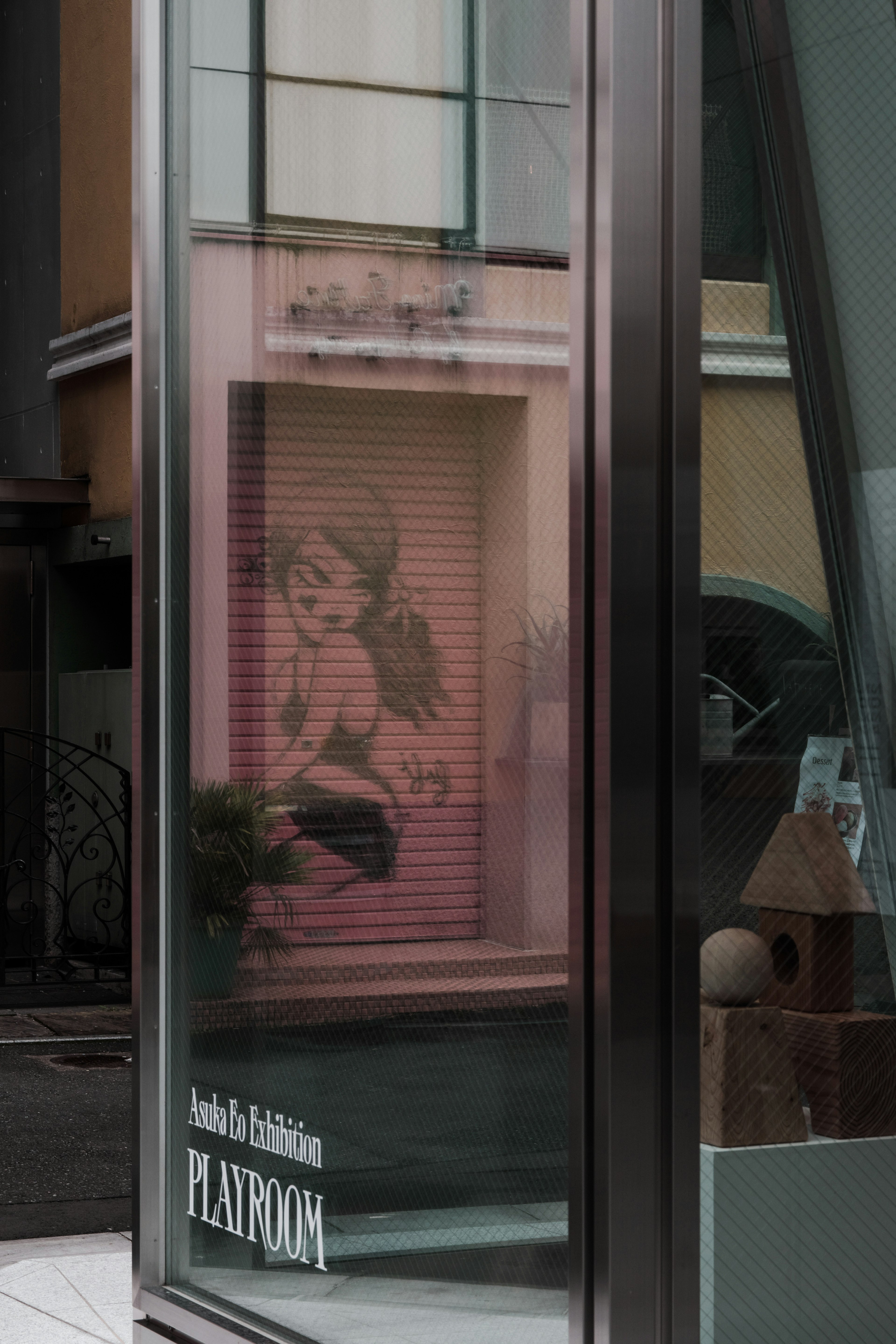 Reflexion einer Kinderillustration in einem Schaufenster mit dem Wort PLAYROOM