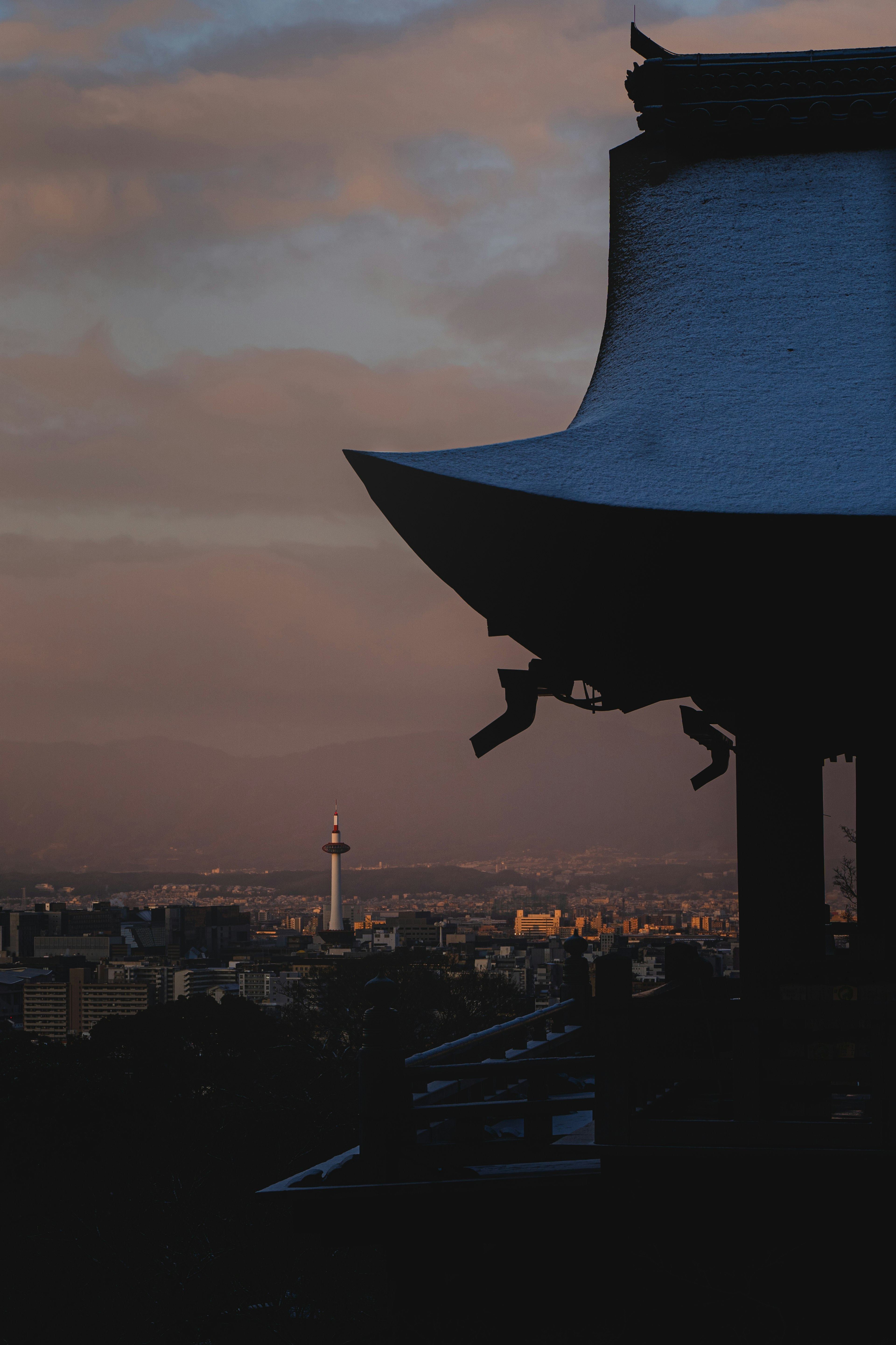 Silhouette eines traditionellen Gebäudes vor einer Dämmerungsstadtlandschaft