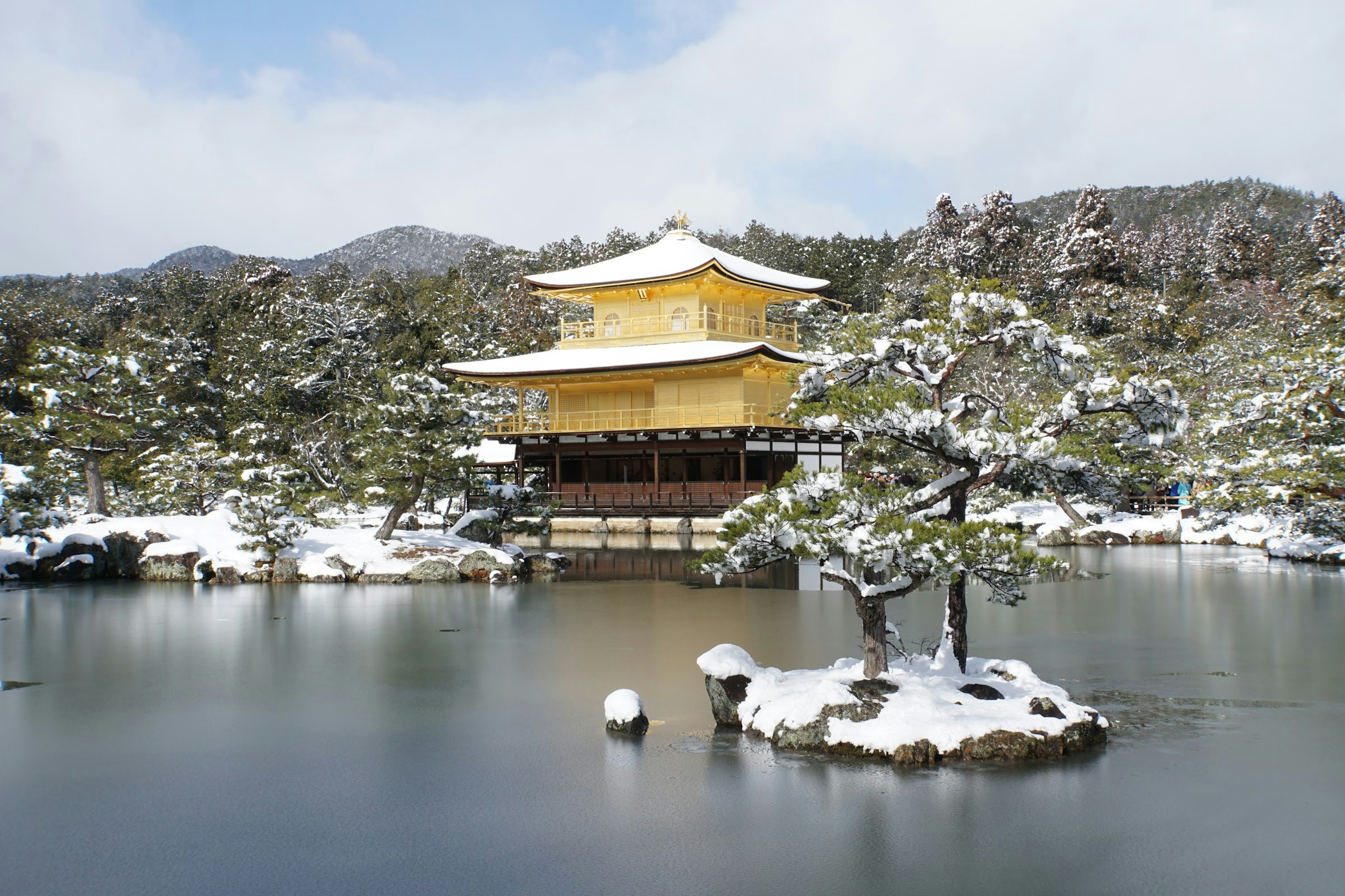 Kinkaku-ji im Winter Schnee goldener Tempel umgeben von ruhigem Teich