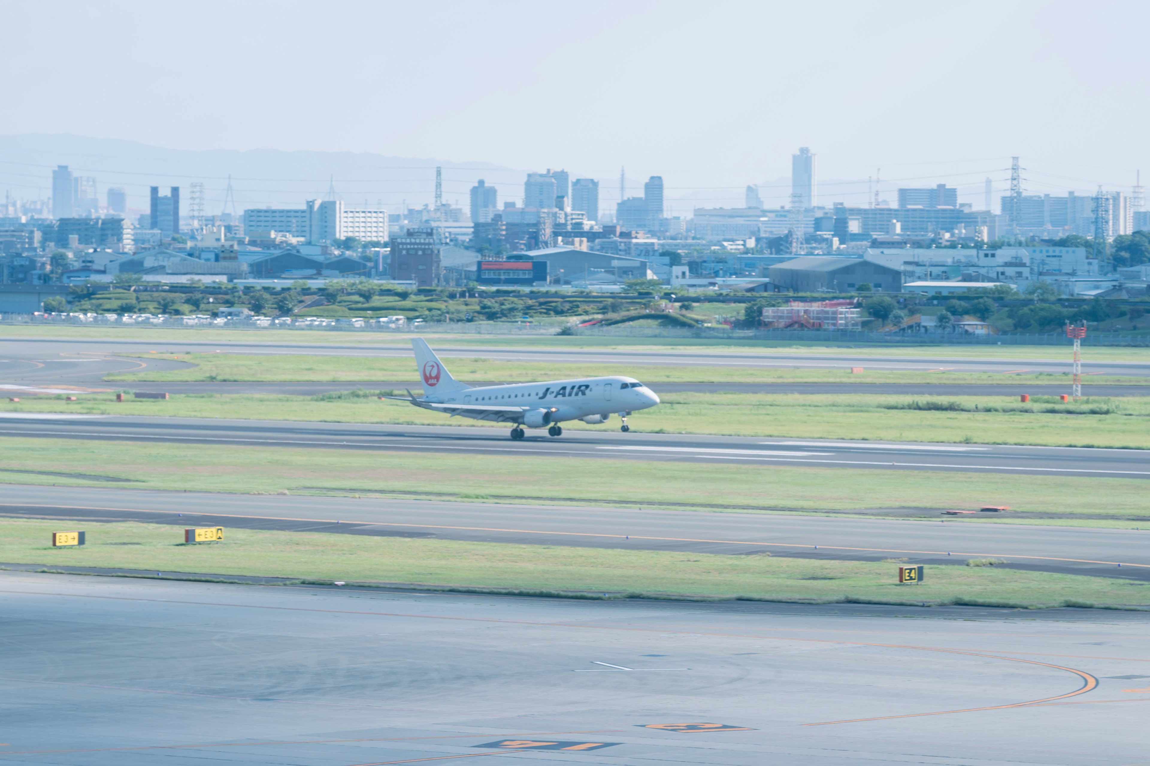 滑走路を走る飛行機と都市の背景