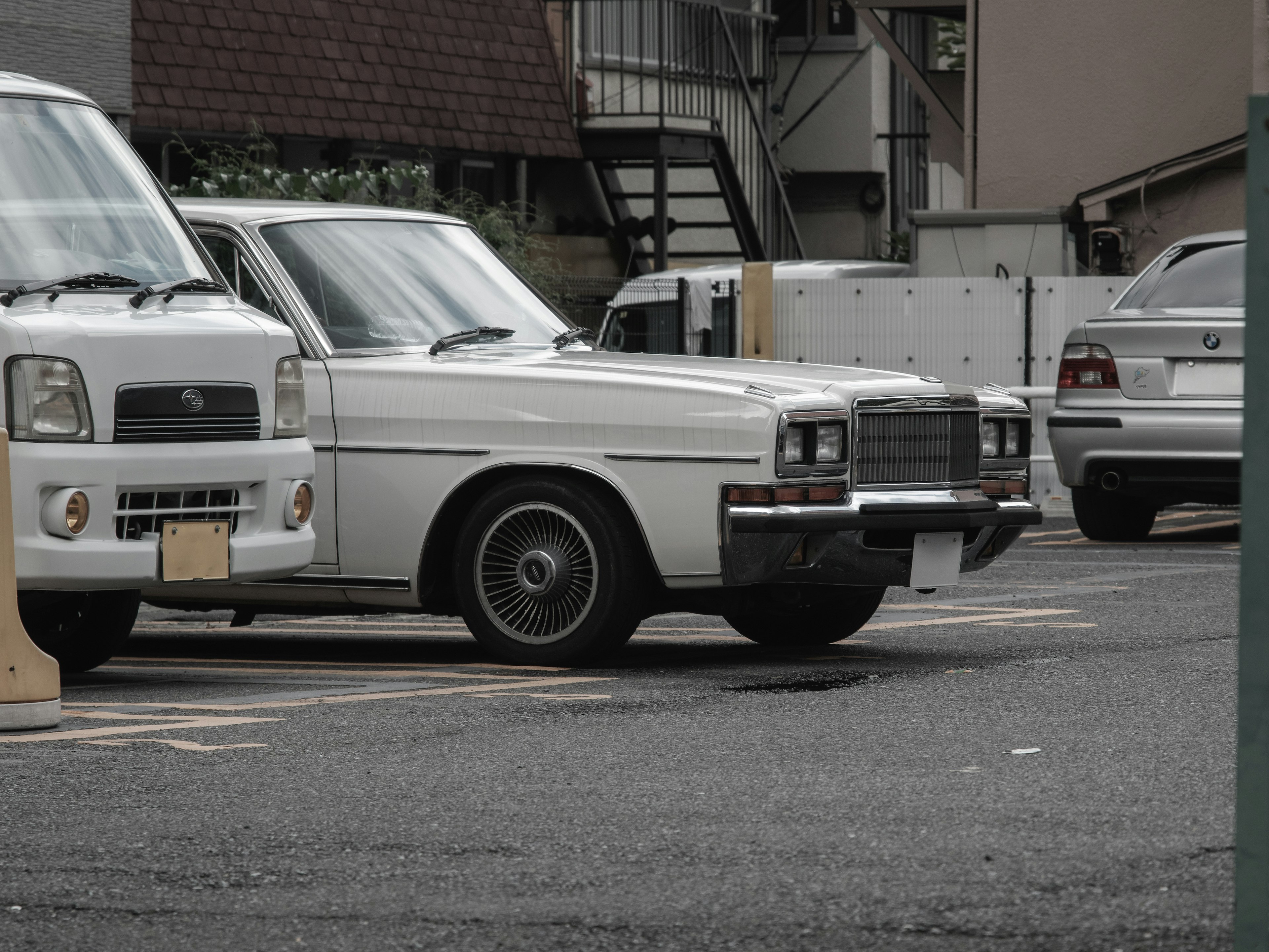 Mobil klasik putih diparkir di tempat parkir