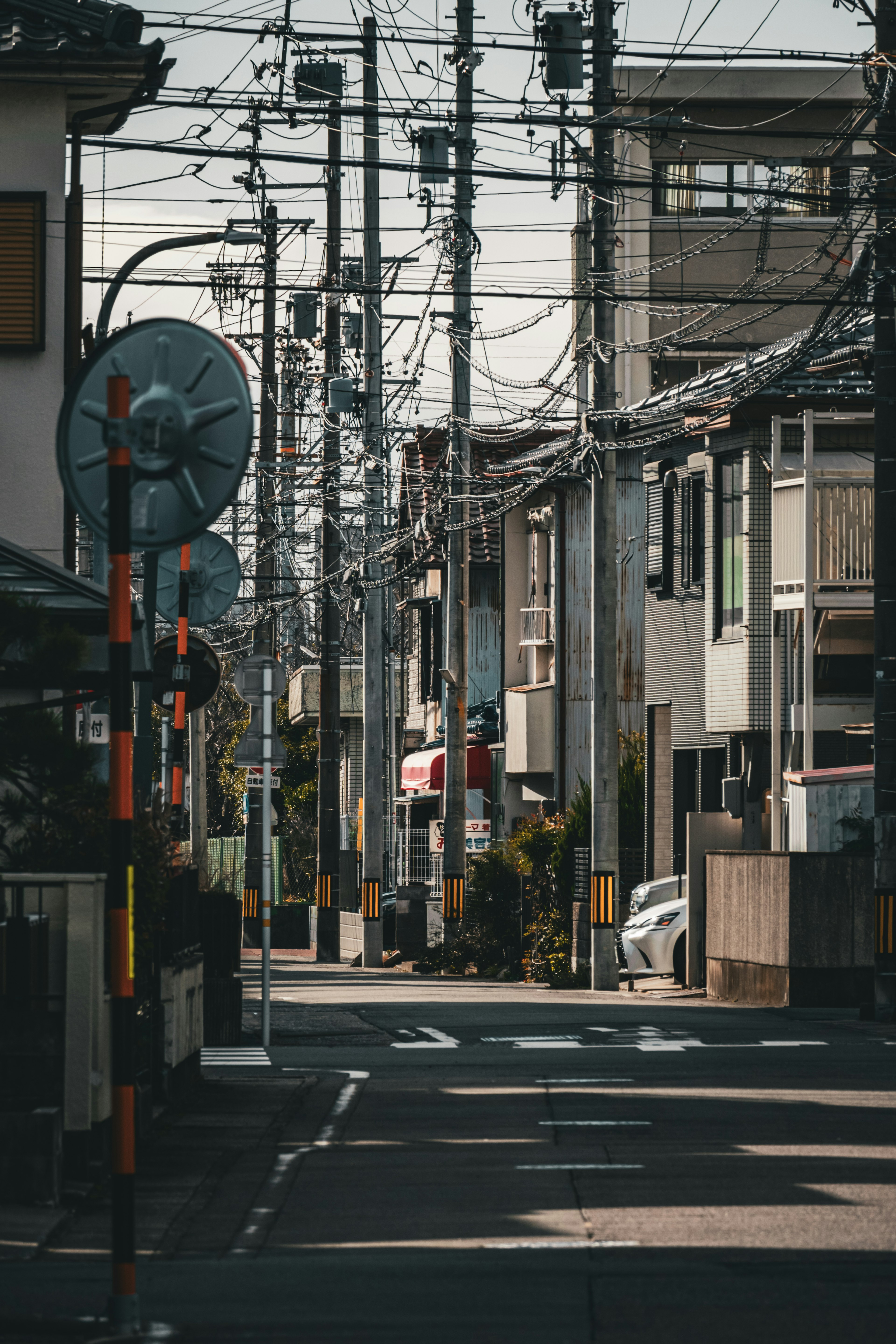 Narrow street in Japan lined with buildings and power lines