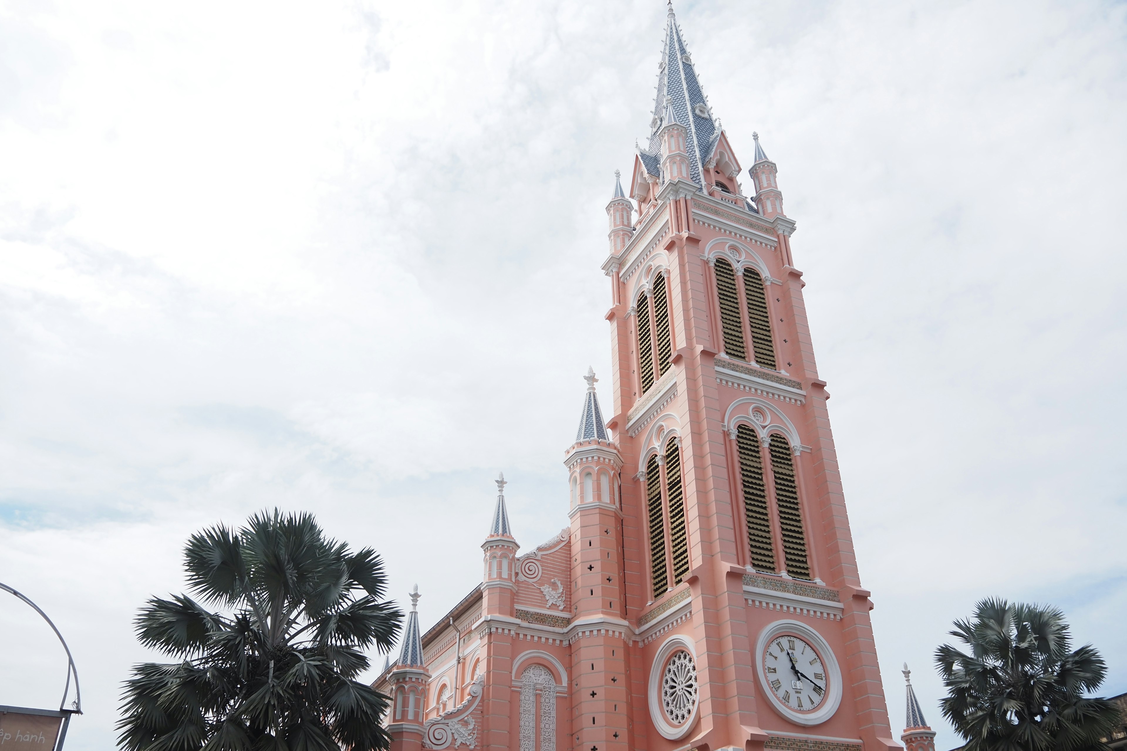 Torre de iglesia con exterior rosa y gran reloj