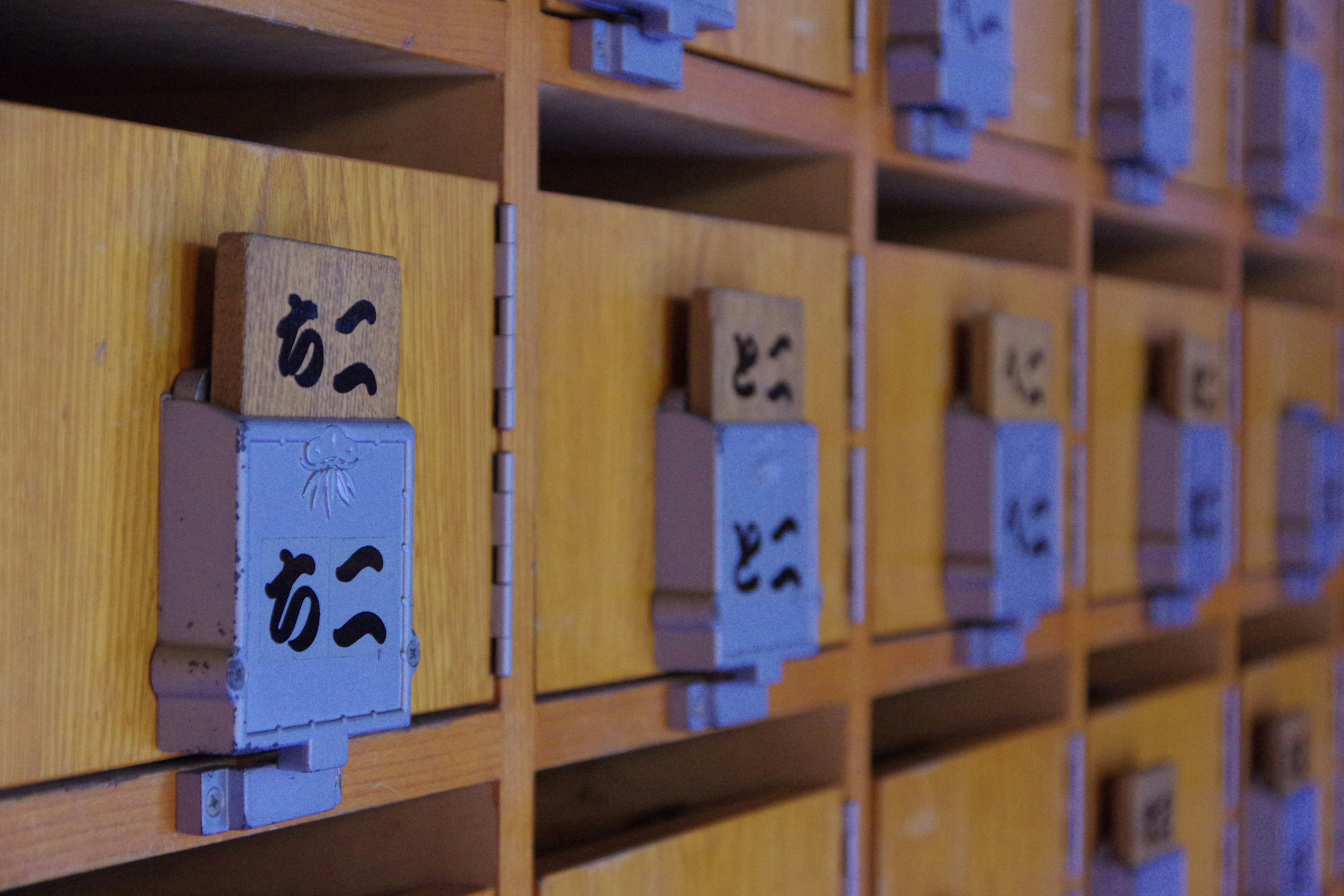 Wooden drawers lined with small boxes and Japanese characters