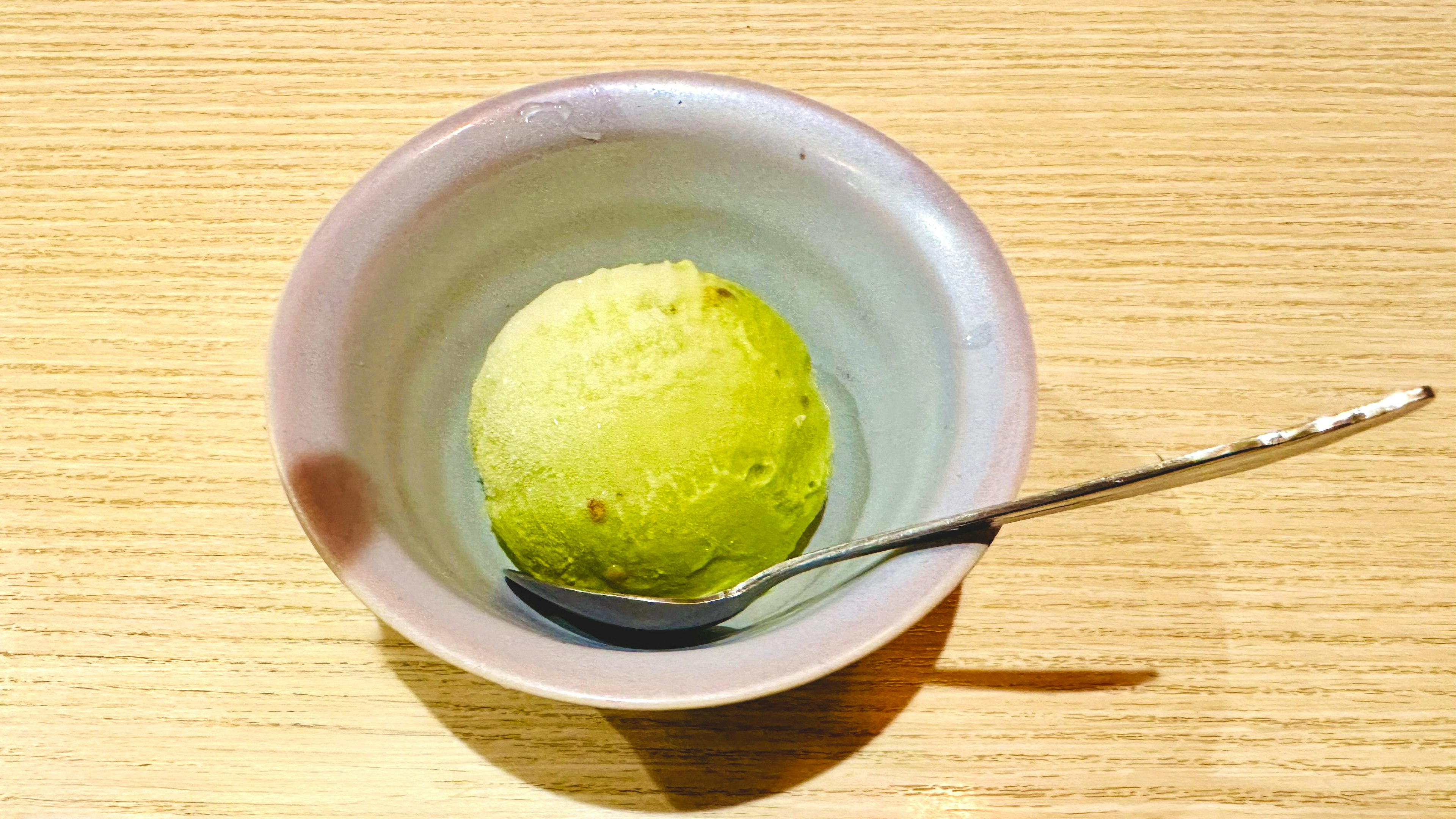 Una ciotola di gelato al tè verde con un cucchiaio