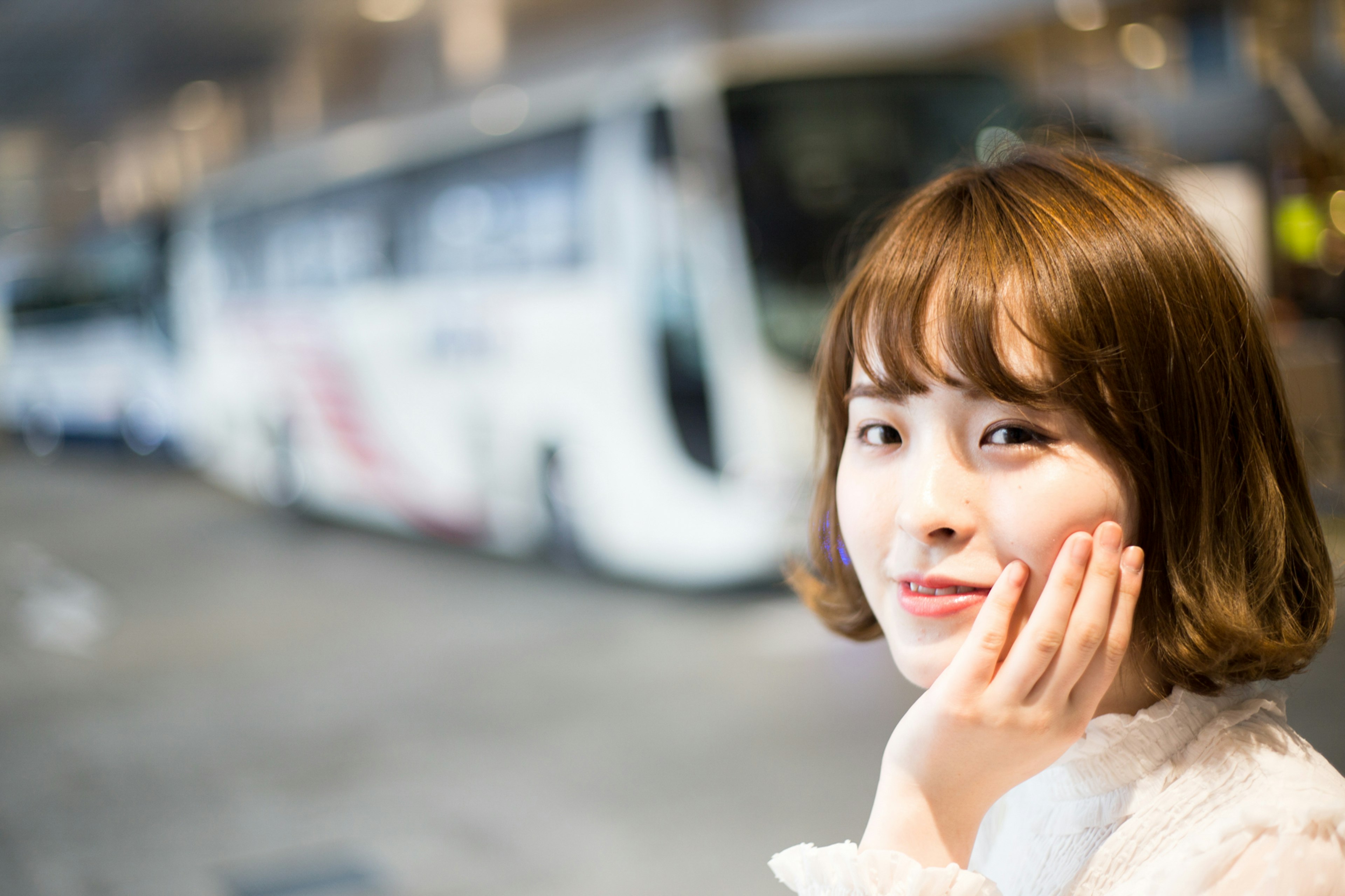 Portrait d'une femme souriante avec un bus en arrière-plan