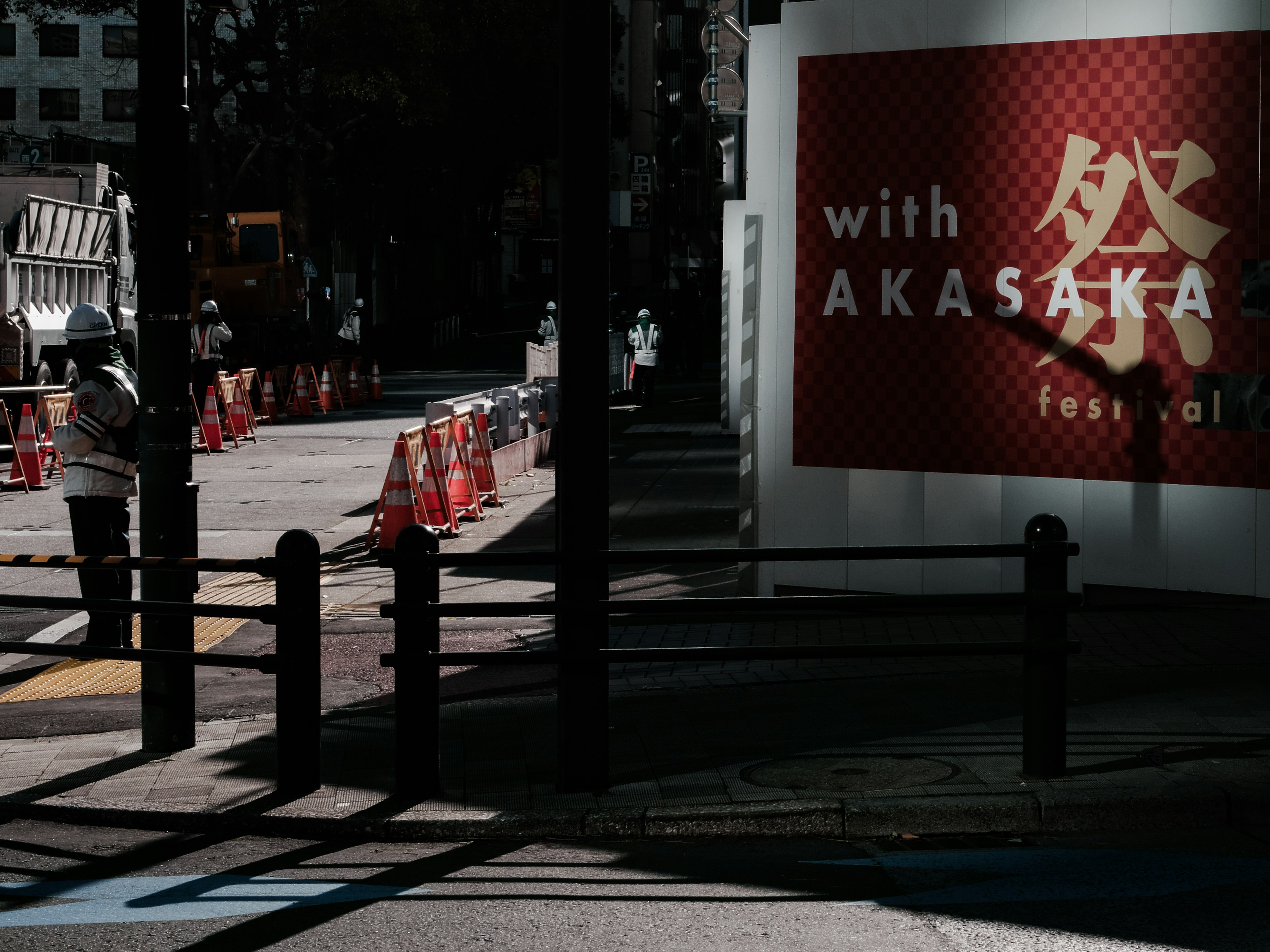 Street corner view featuring a sign for Akasaka and traffic barriers