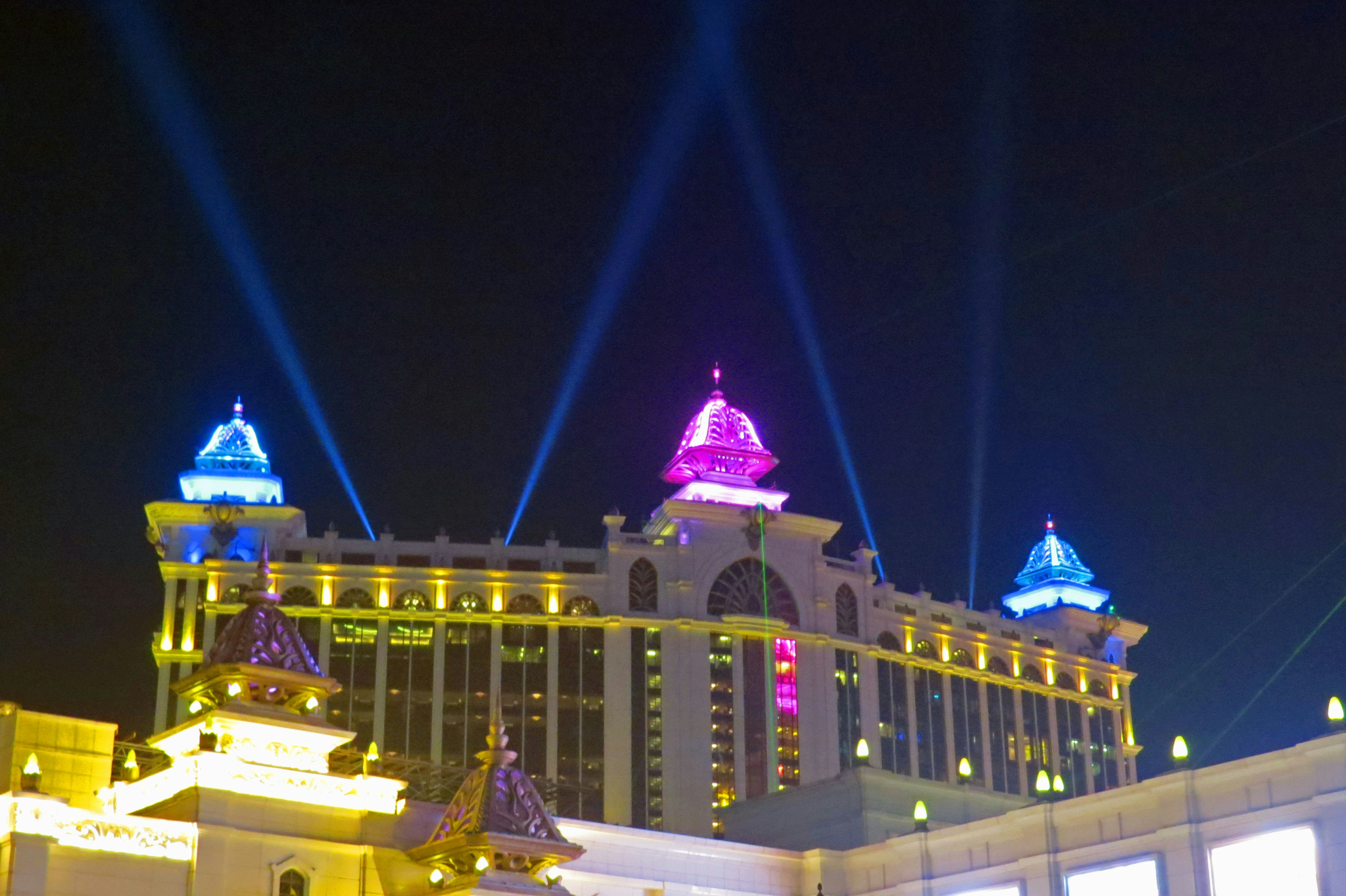 Colorful lights shining on the rooftop of a casino building at night