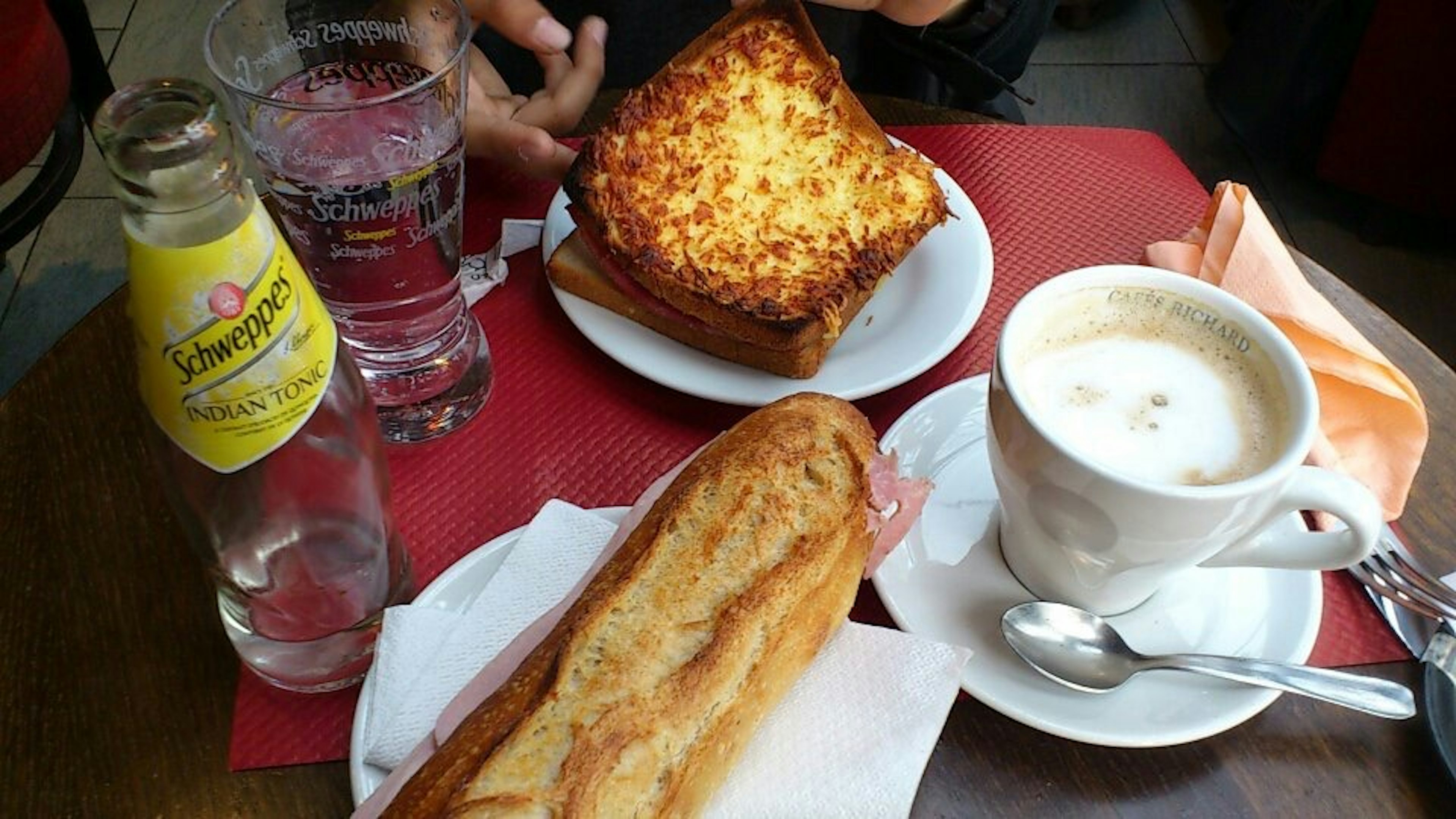 Coffee, toast, sandwich, and sparkling water on a table