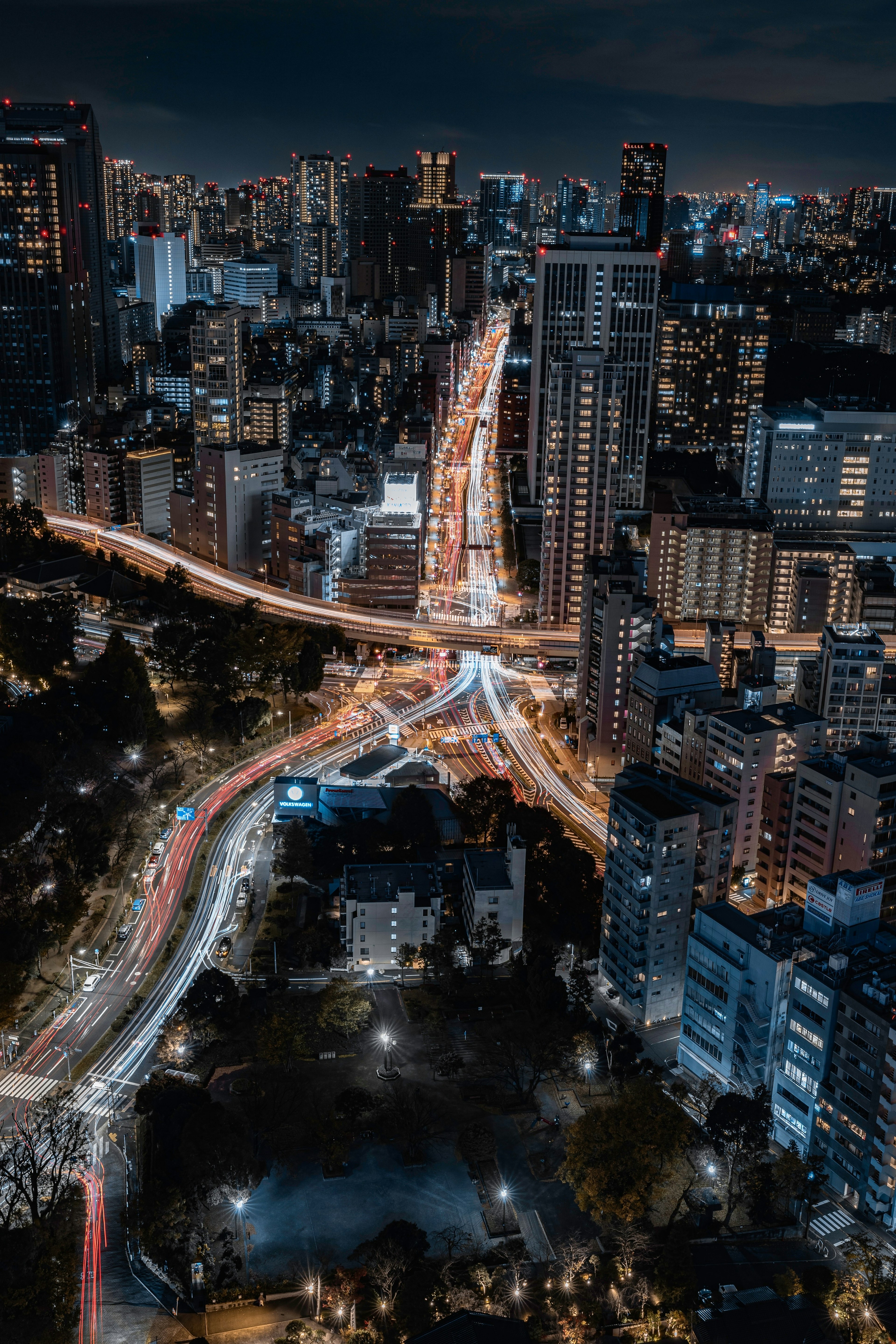 高層ビルが立ち並ぶ夜の都市風景 交差する道路と光の軌跡