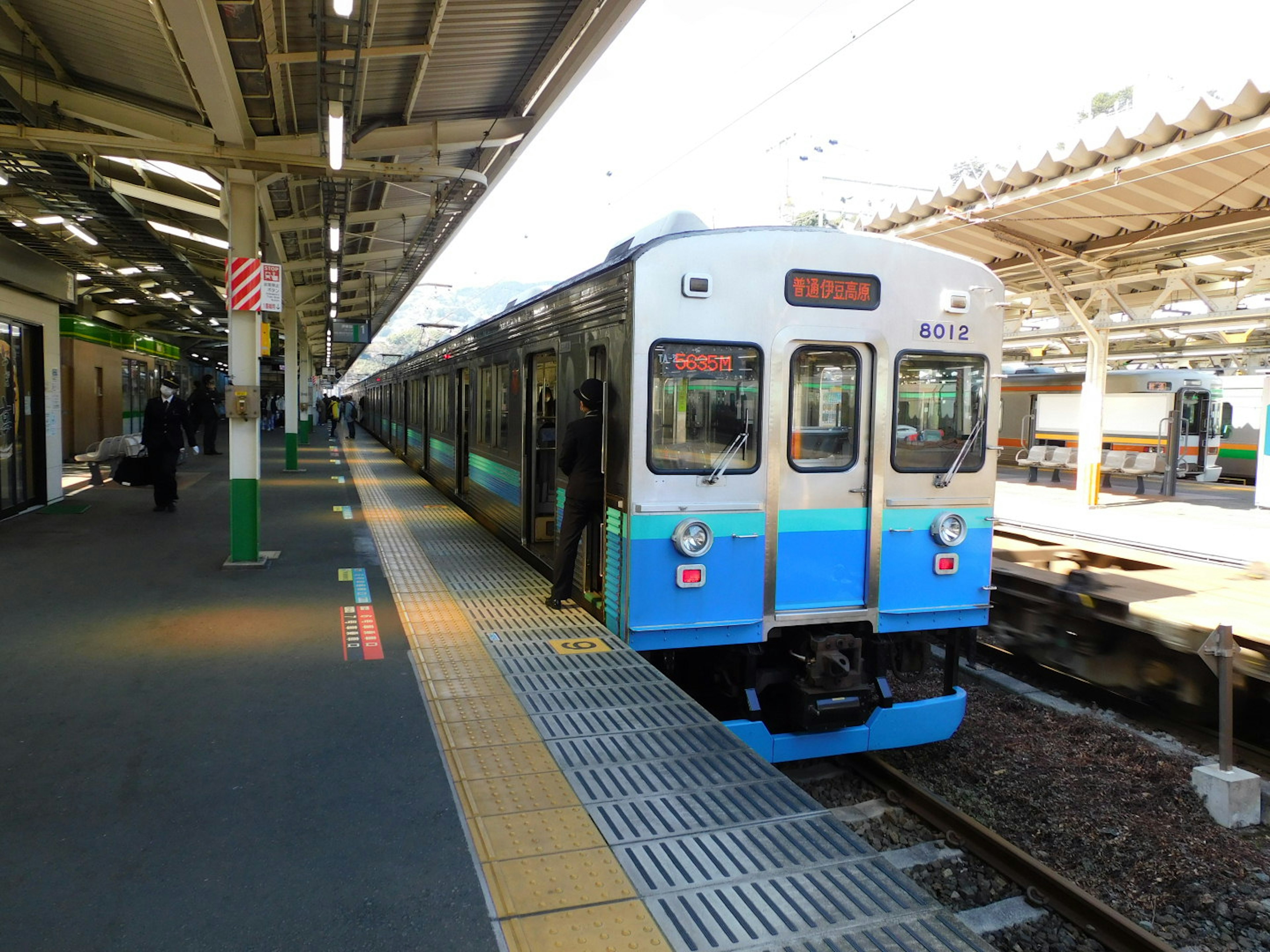 Blue and white train stopped at a railway station platform