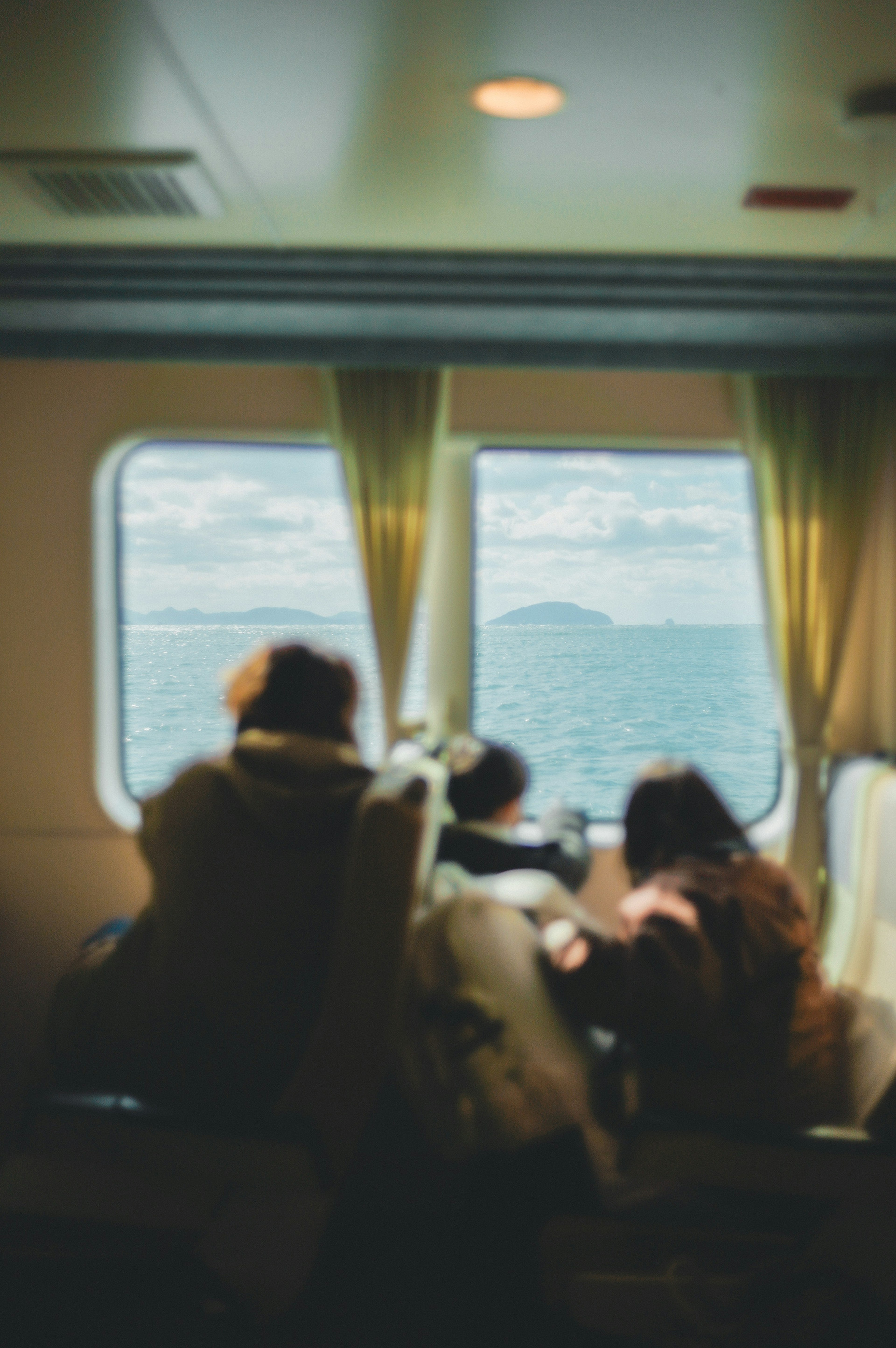 Menschen sitzen am Fenster eines Bootes und schauen auf das Meer