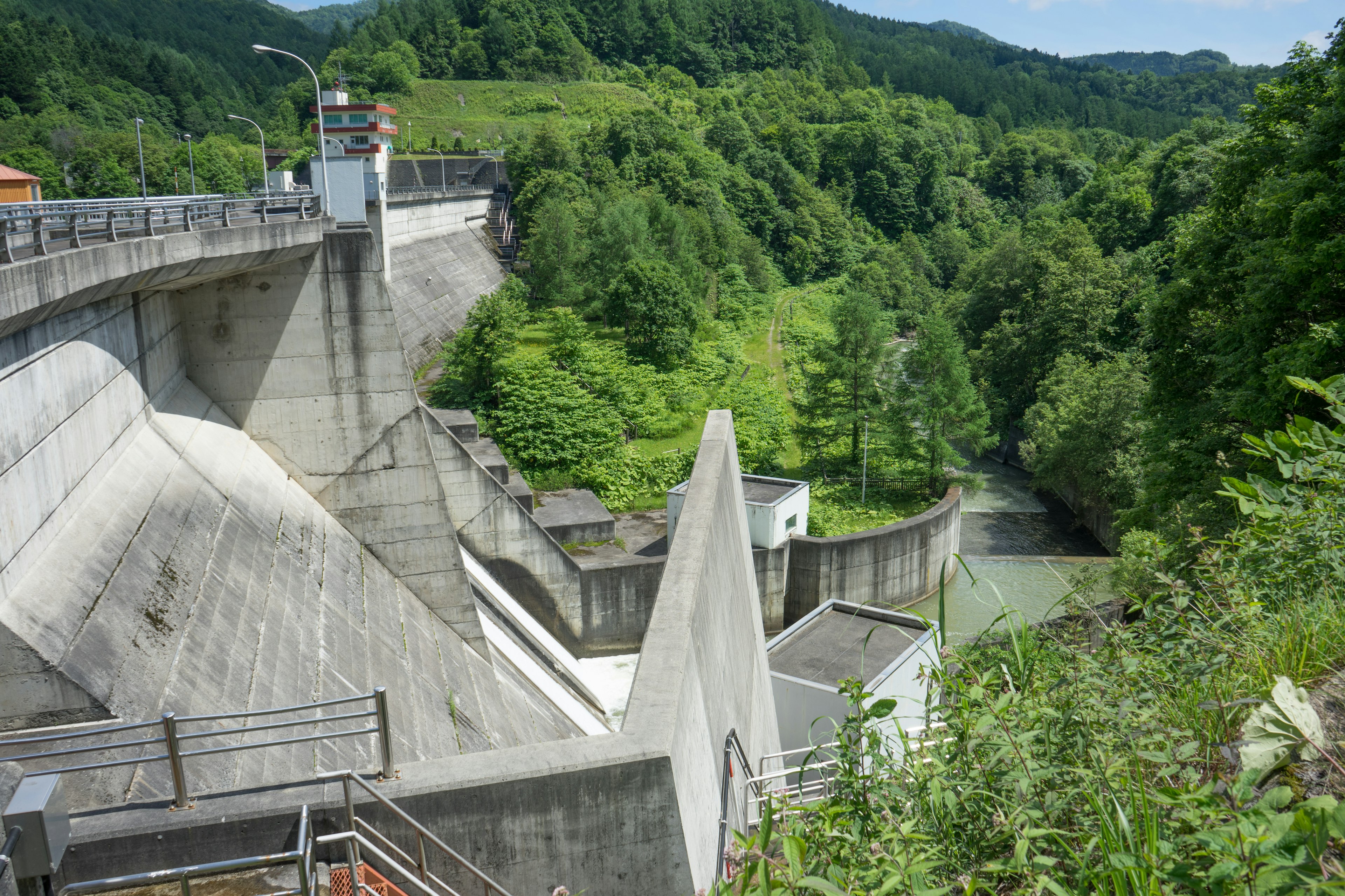 Estructura de presa de concreto con entorno verde