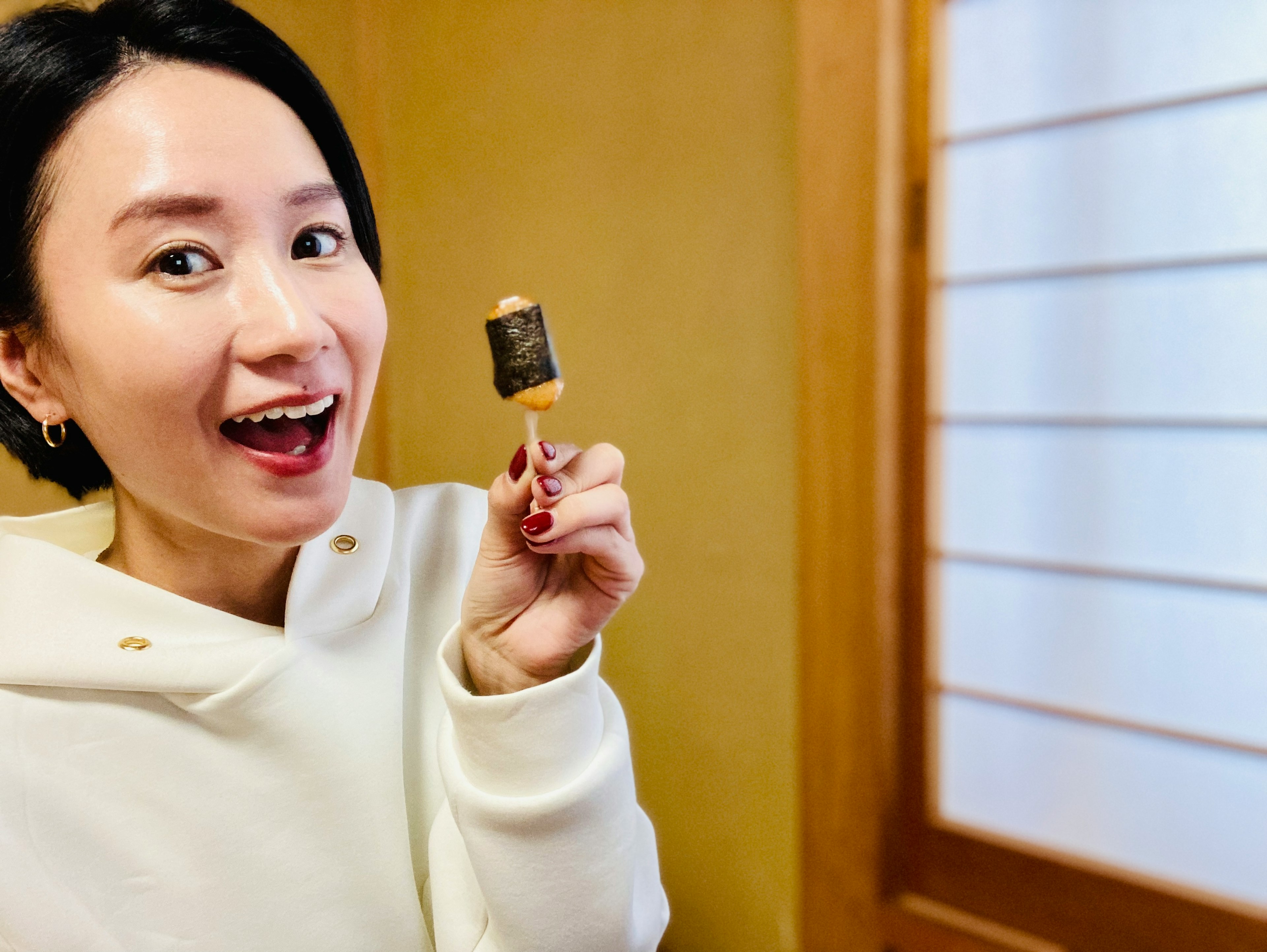 A woman smiling and holding an ice cream pop