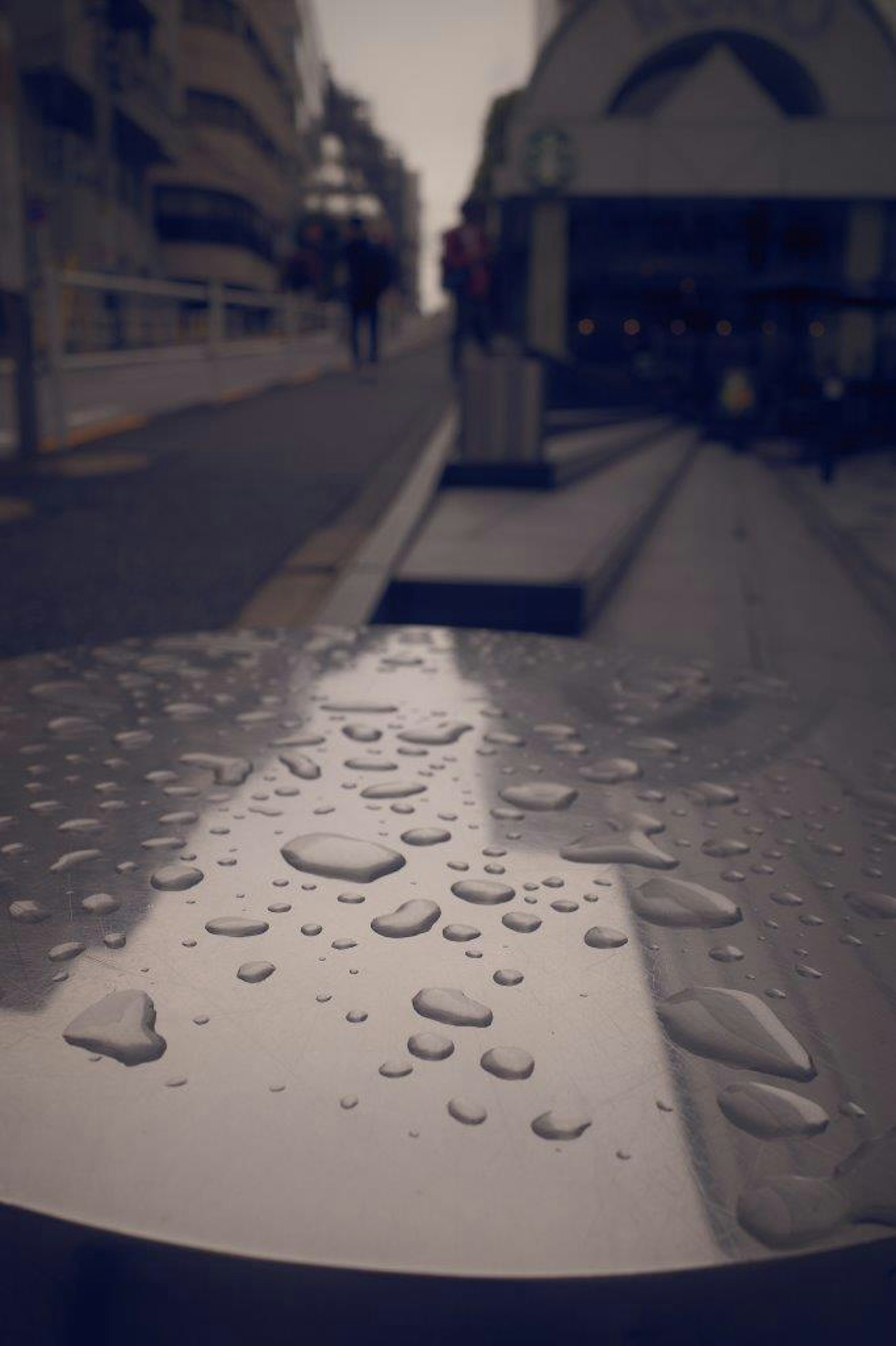 雨滴が付いた金属の表面と背景の都市の風景