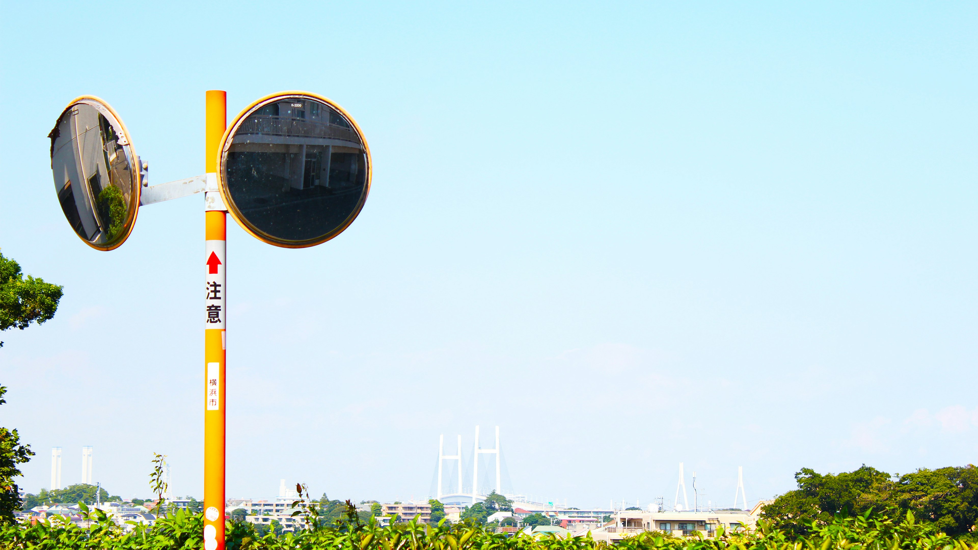 Orange pole with two round mirrors under a blue sky