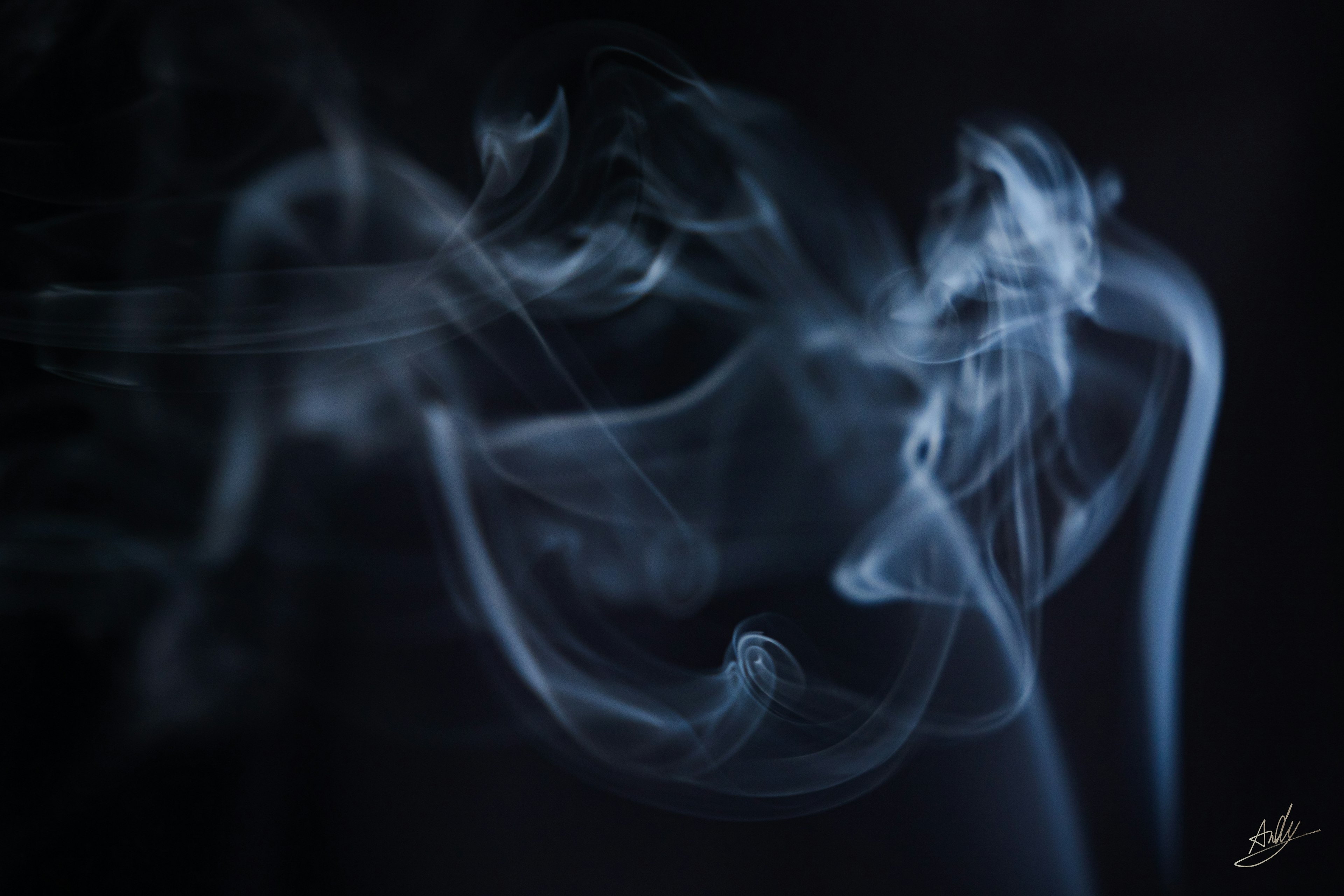 Blue smoke swirling against a black background