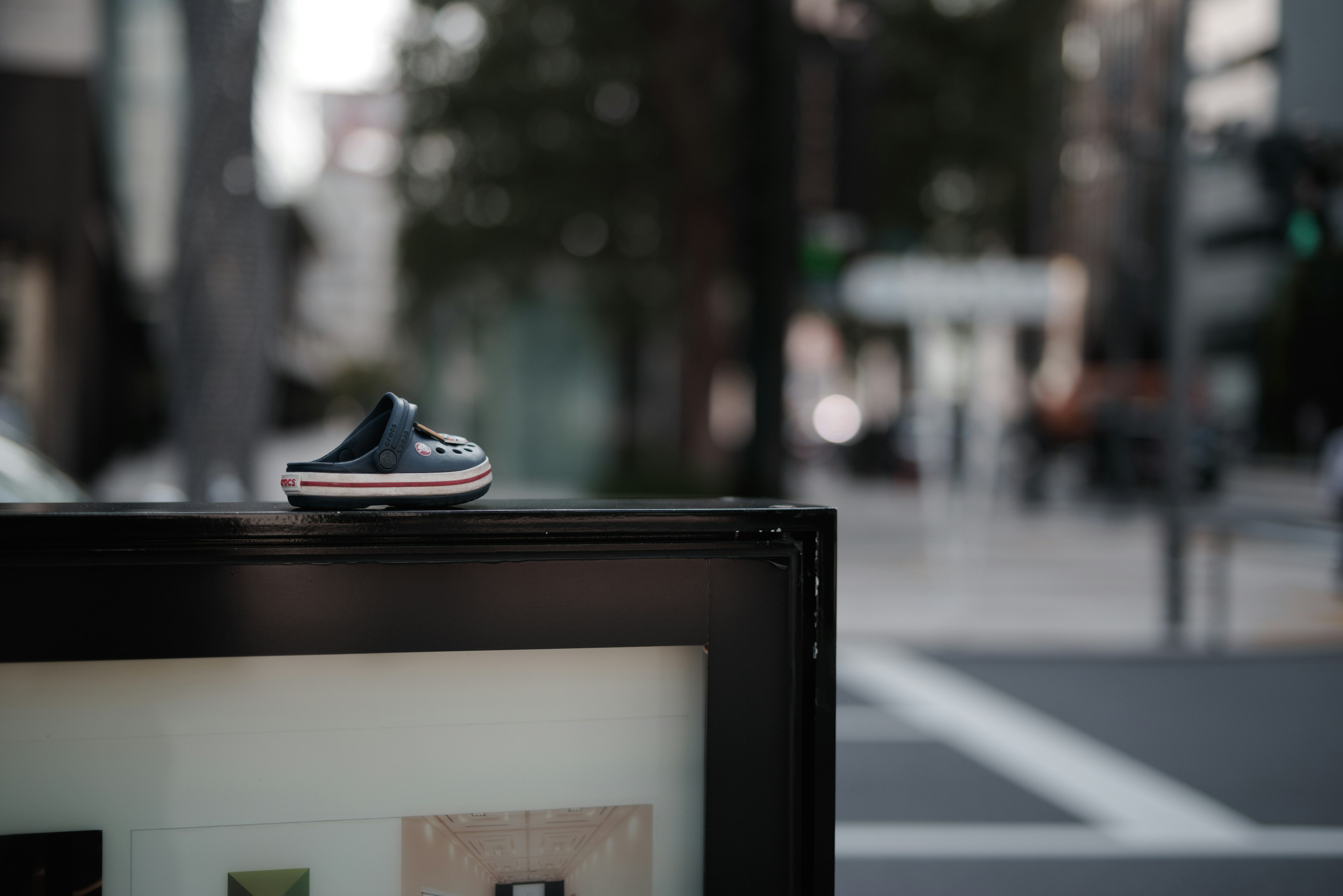 A small shoe placed on a black frame in an urban setting