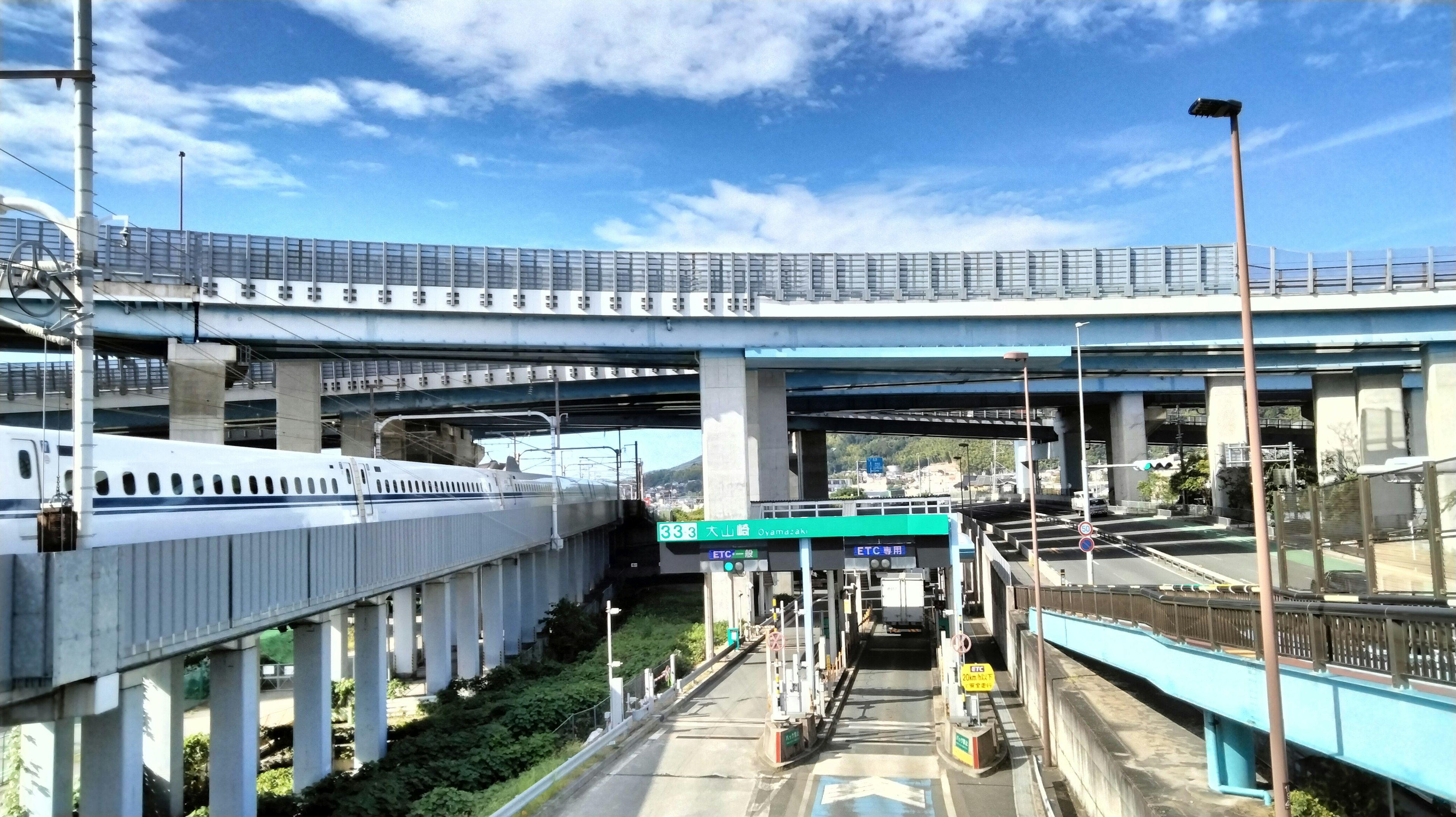 Persimpangan jalan layang dan Shinkansen di bawah langit biru