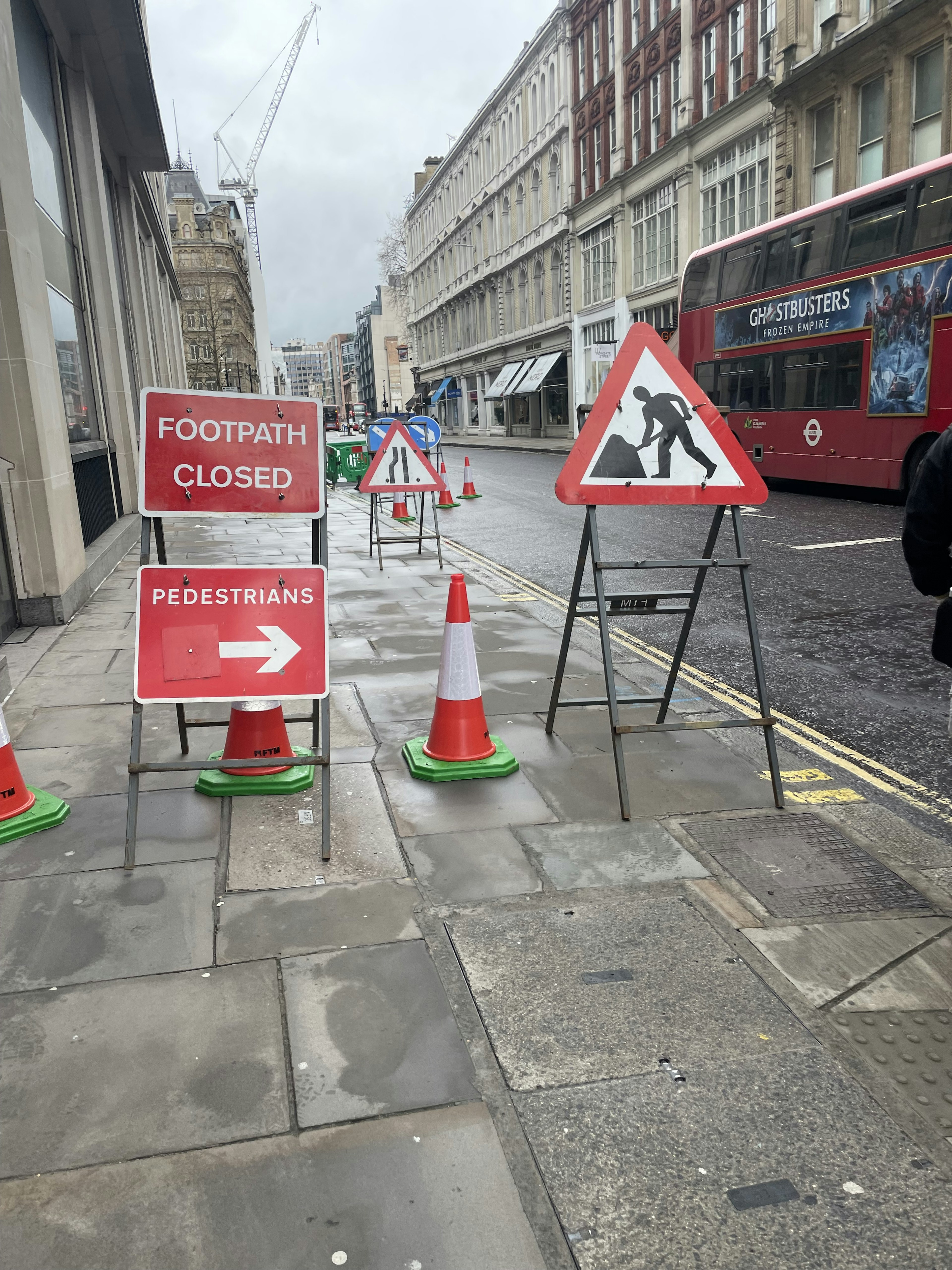 Escena de calle con señales de peatones cerrados y señales de advertencia de construcción