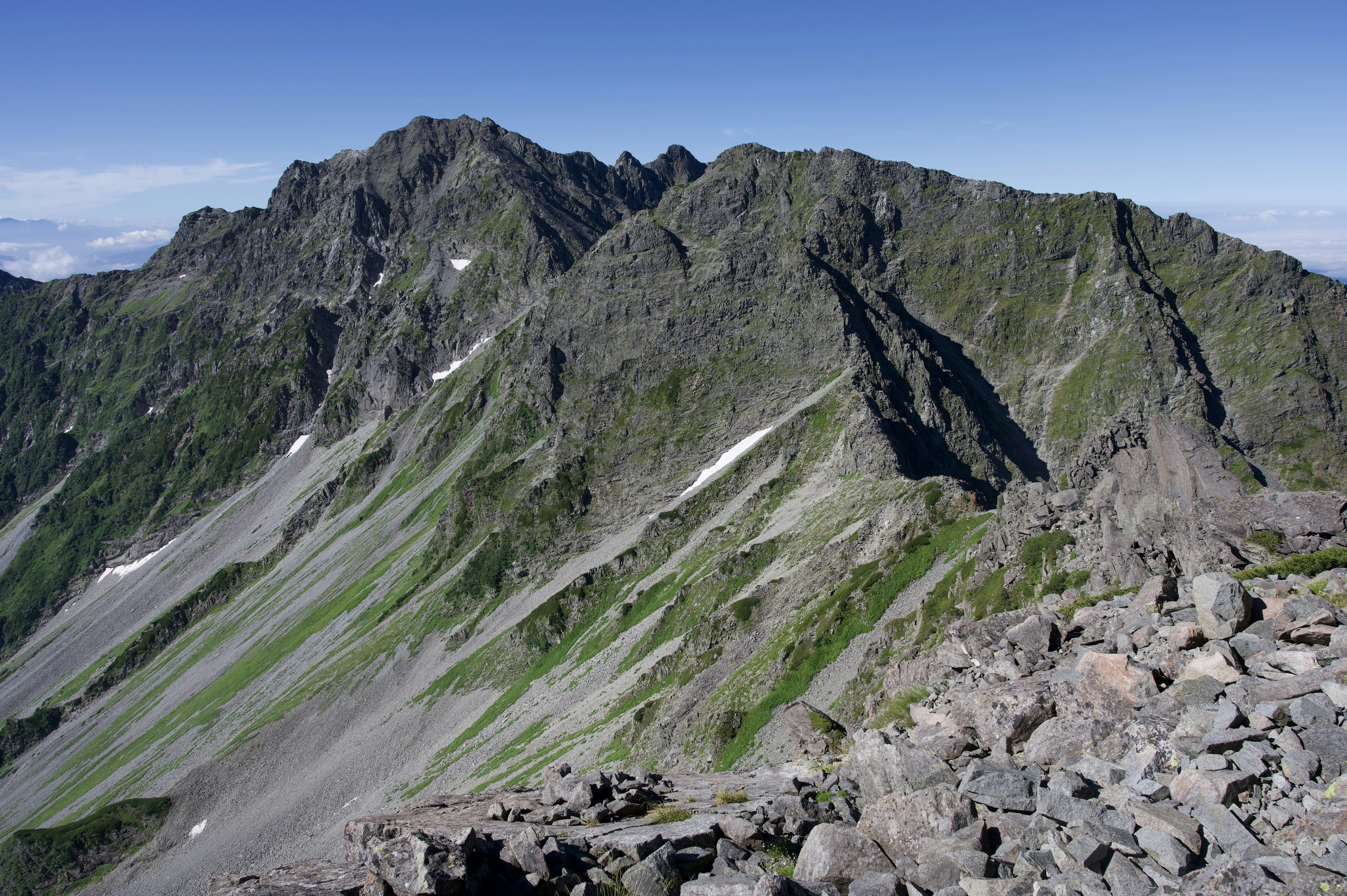 Expansive view of green mountains and rocky terrain