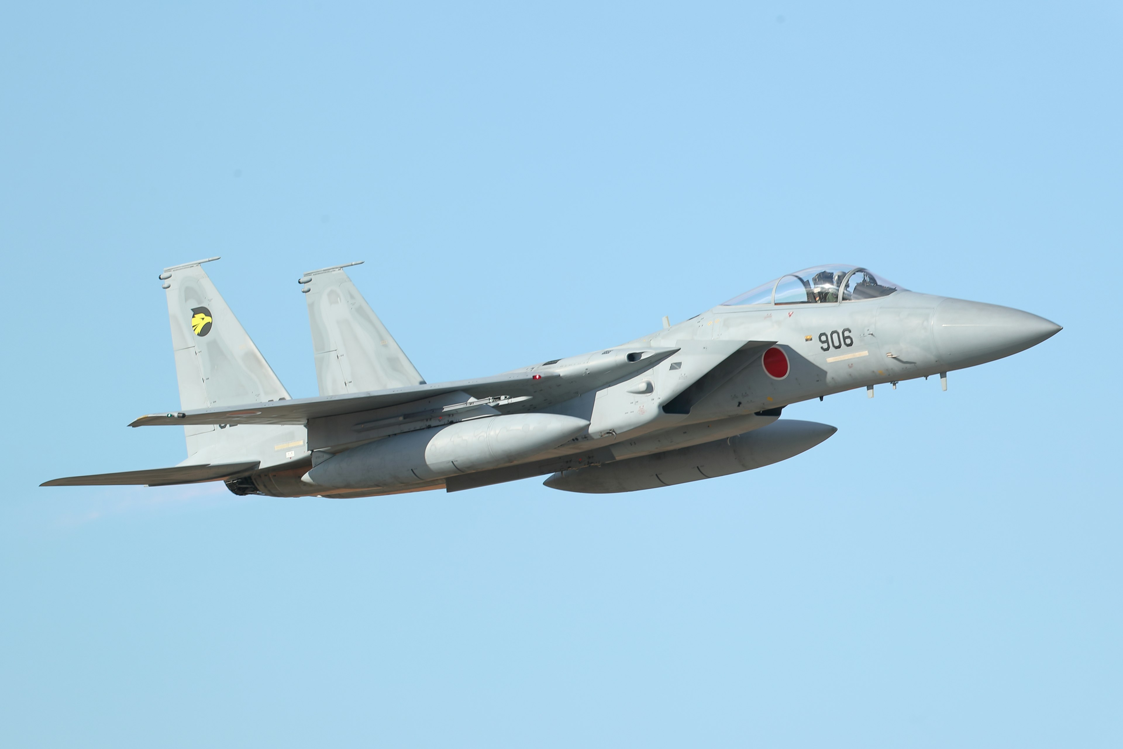 F-15 fighter jet flying against a blue sky