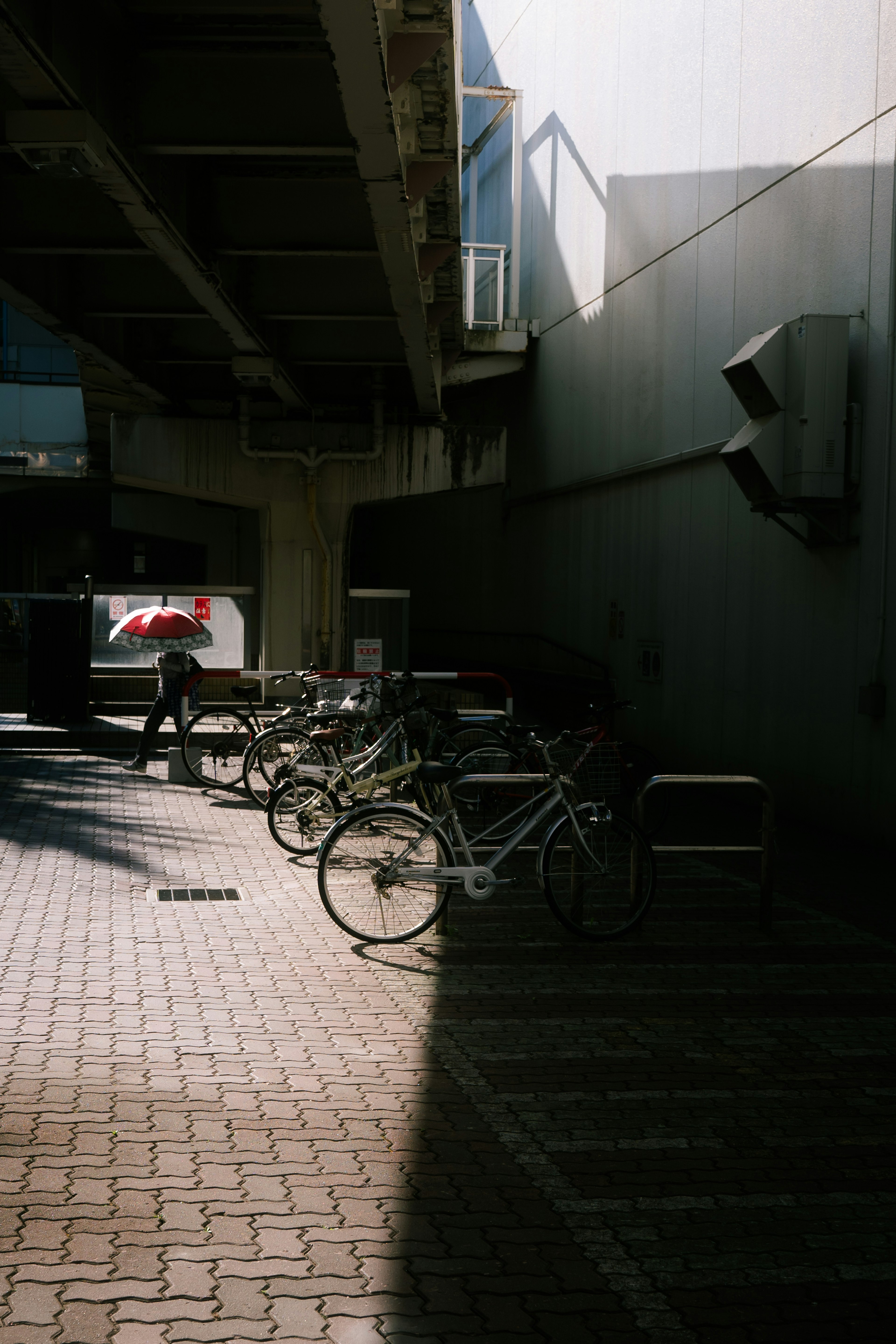 影の中に並ぶ自転車と明るい背景の都市風景