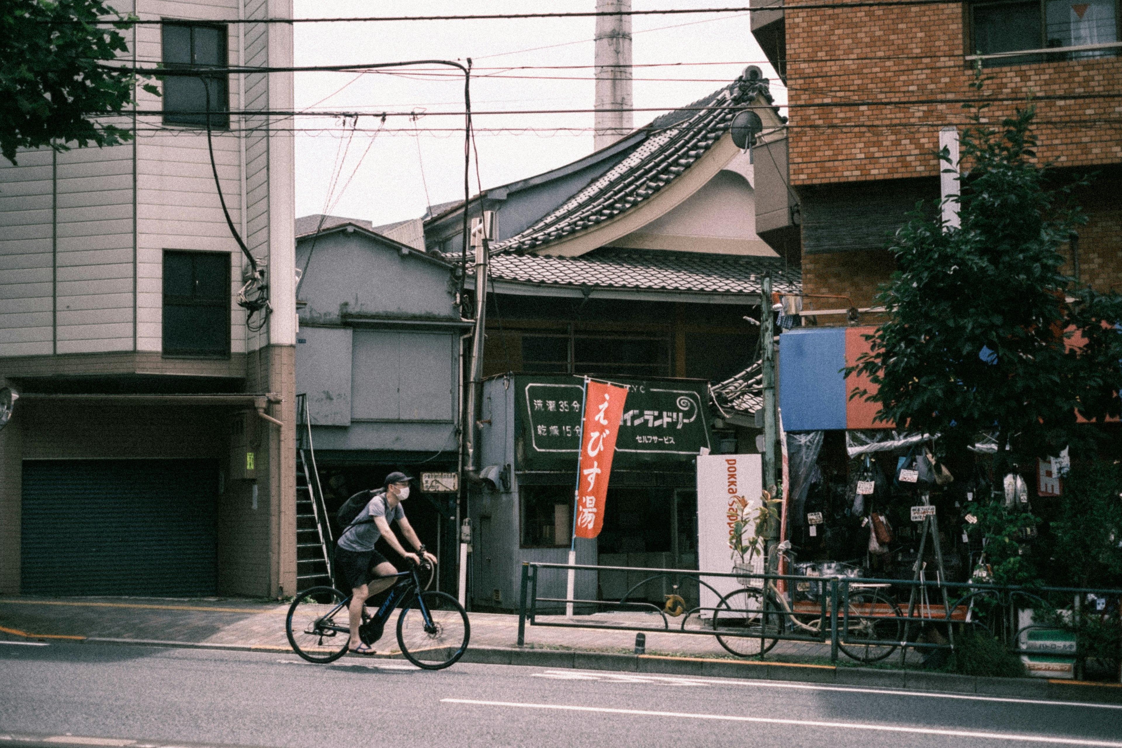 A man riding a bicycle past traditional buildings