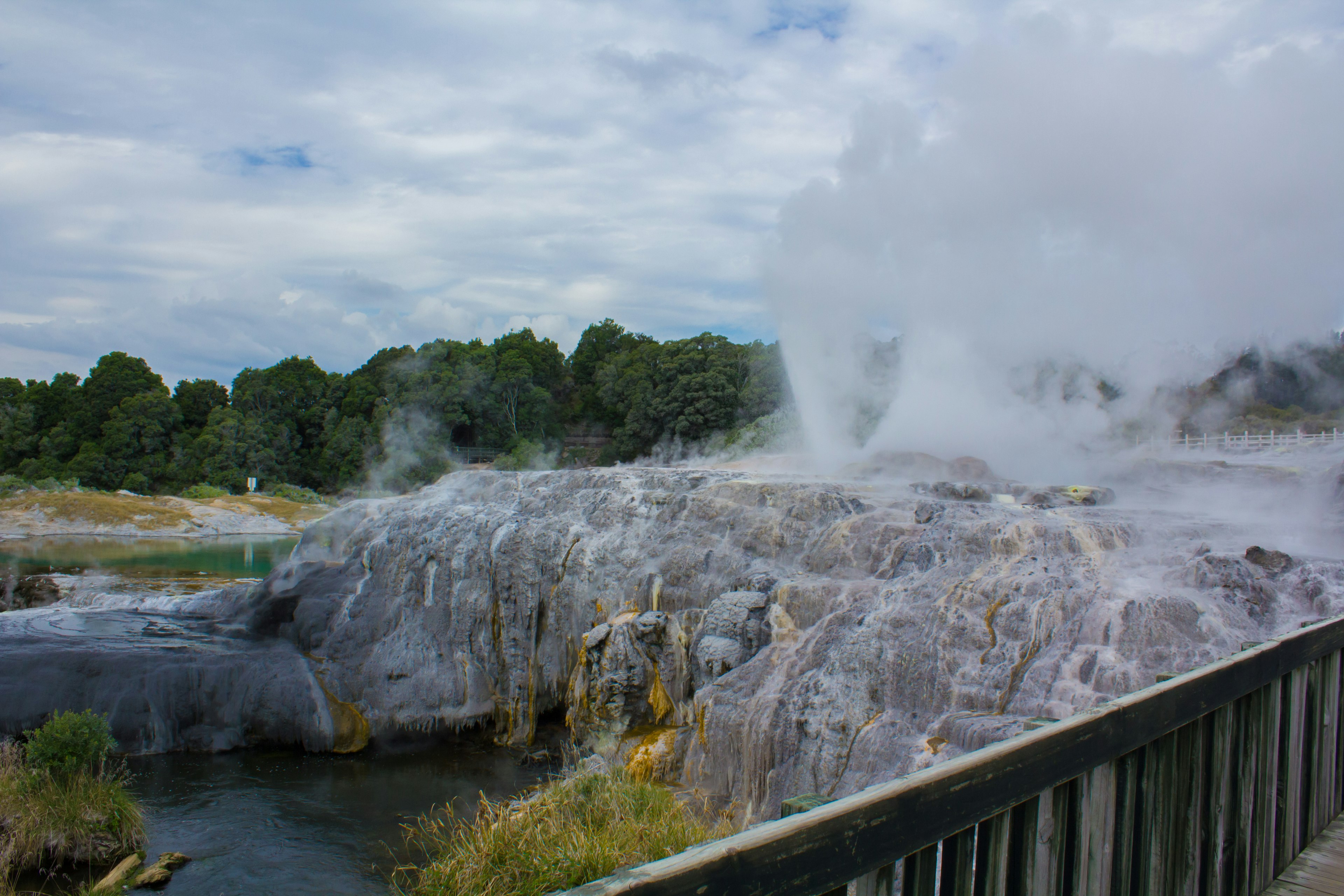 Landscape featuring hot springs with steam rising and natural scenery