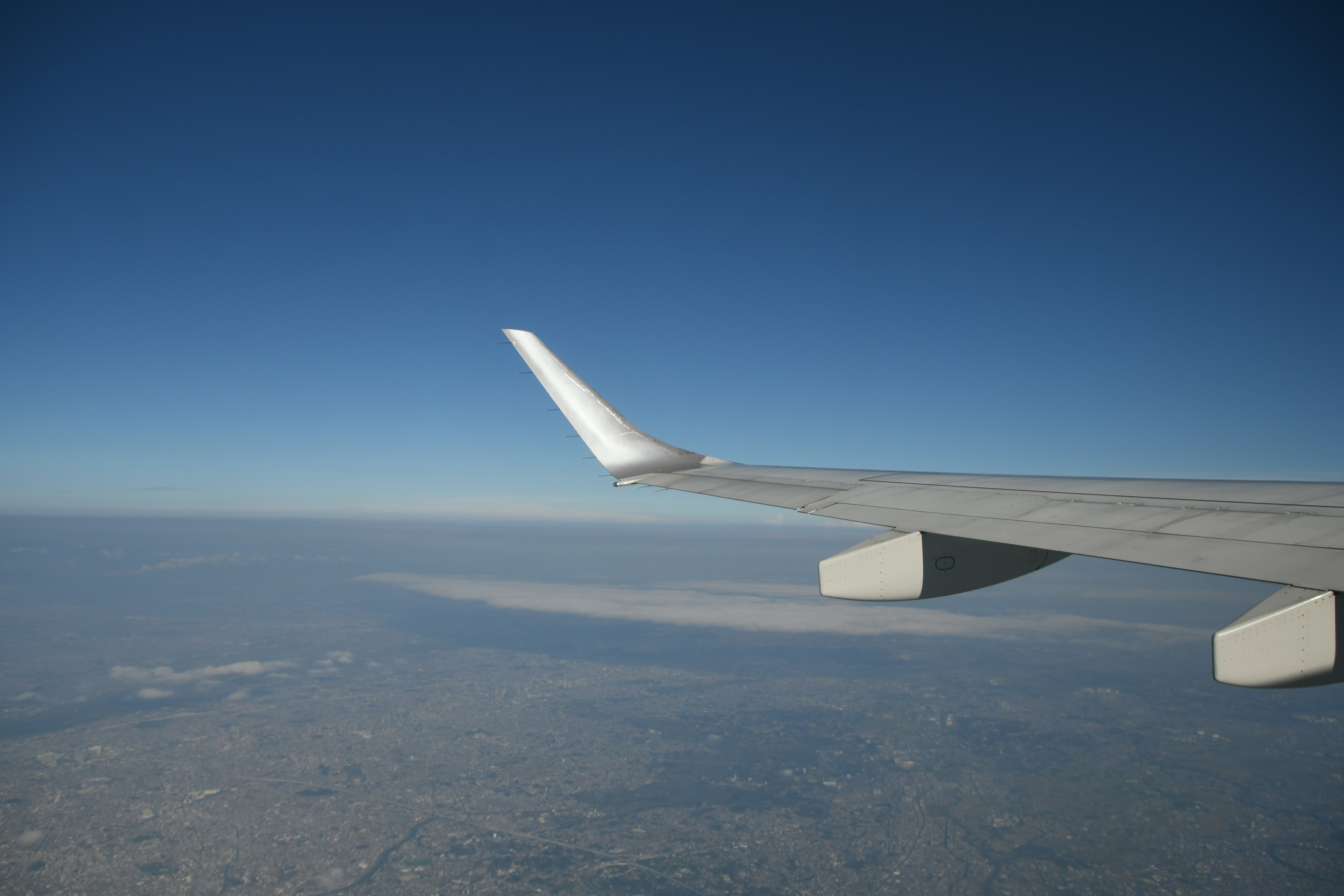 Airplane wing with clear blue sky