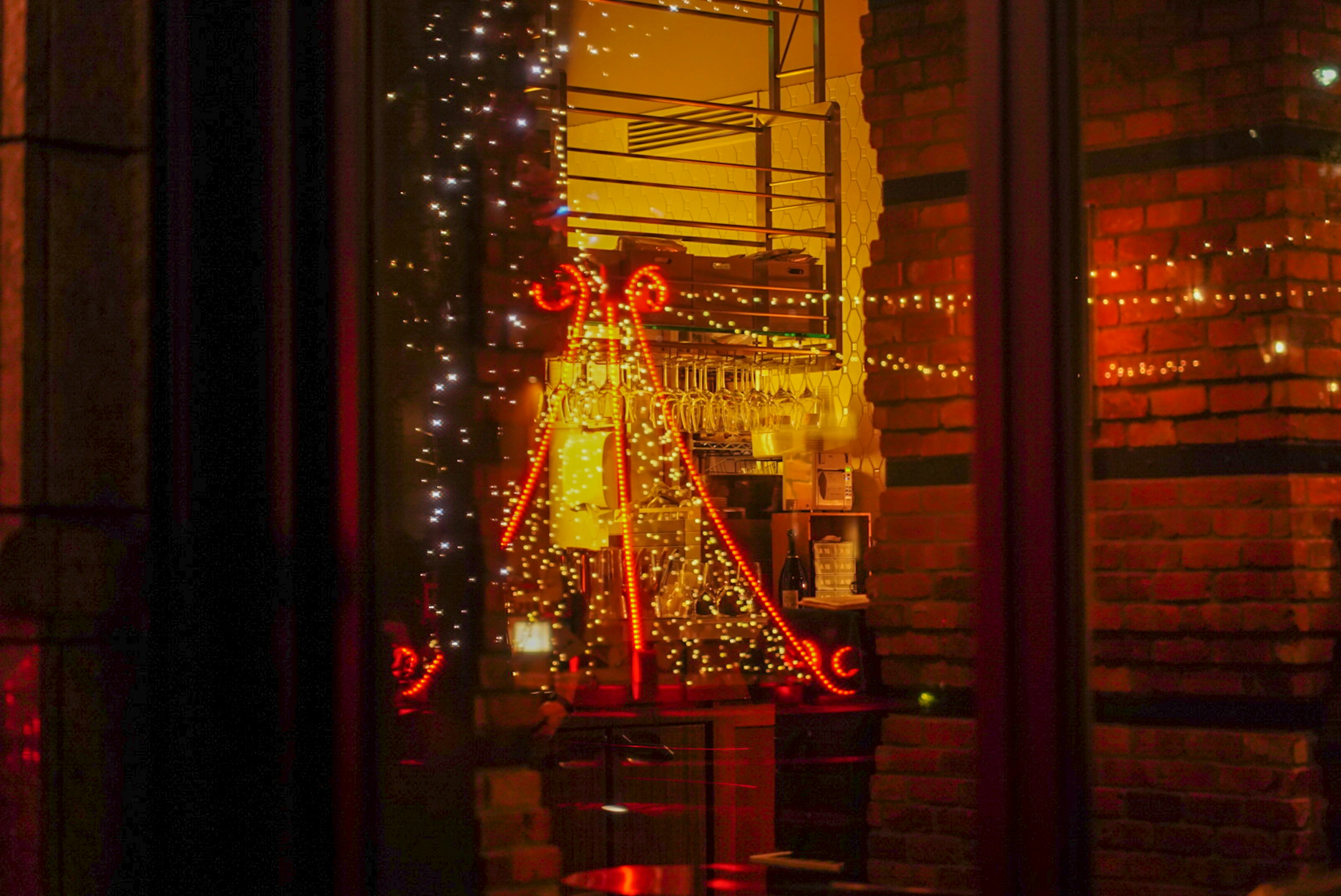 Weihnachtsbaumlichter und Dekorationen durch ein Fenster gesehen