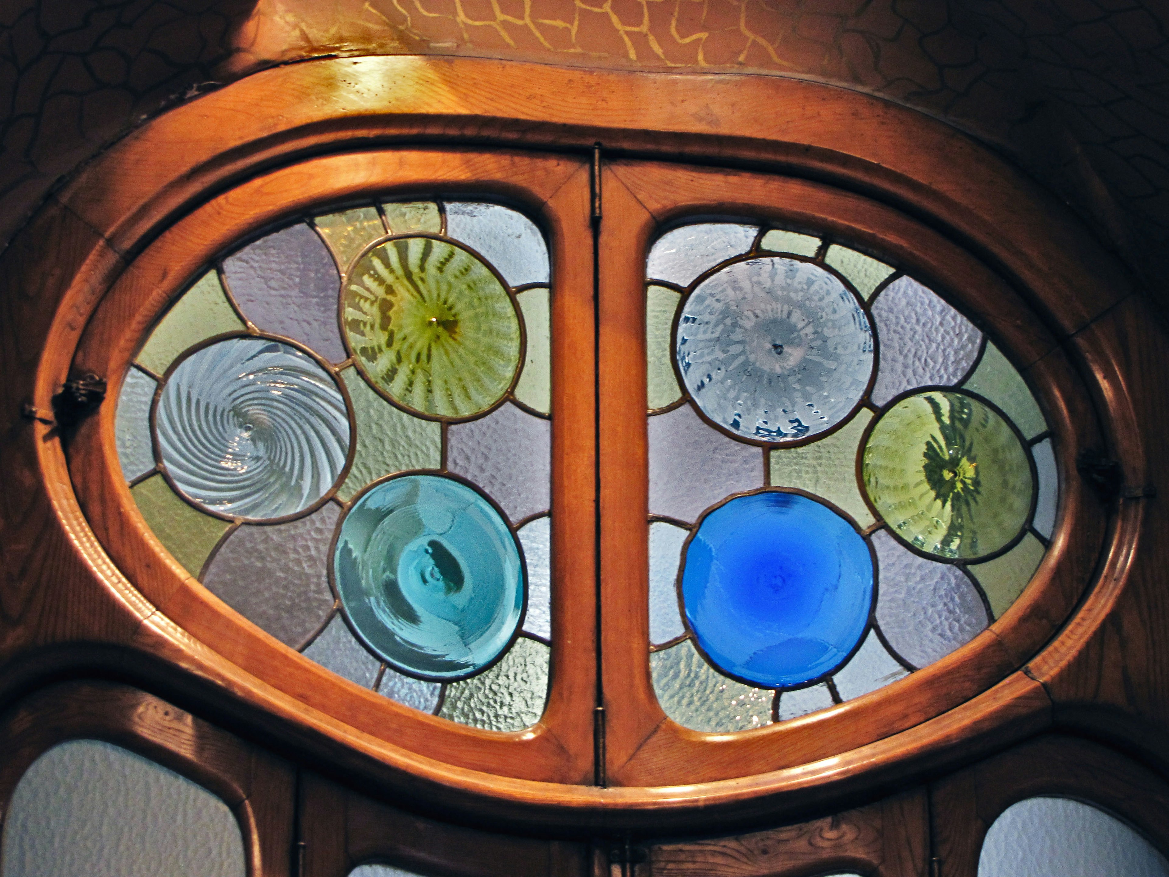 Colorful stained glass window with unique circular designs and patterns