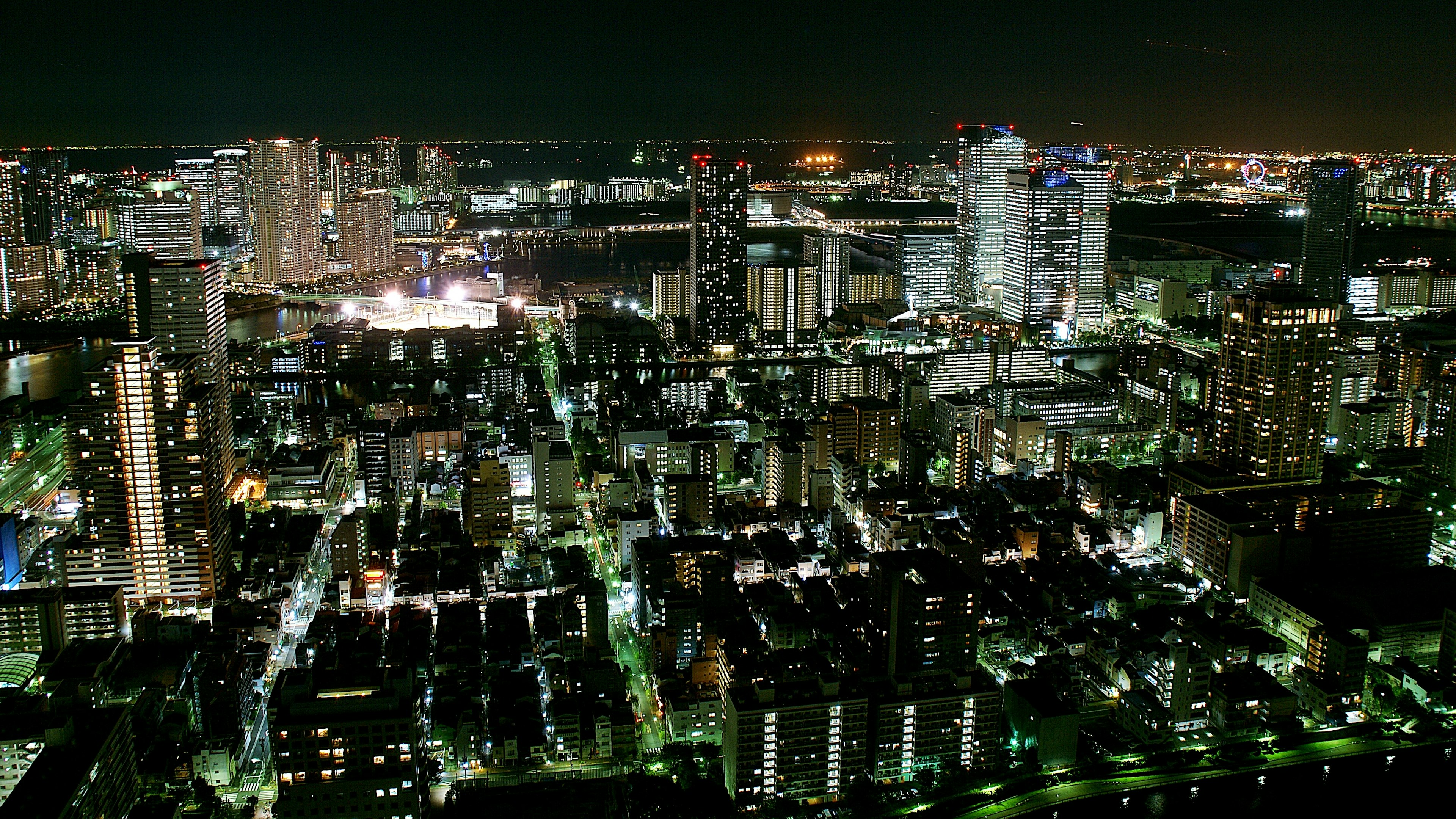 Vista notturna del paesaggio urbano di Tokyo con grattacieli illuminati e lampioni