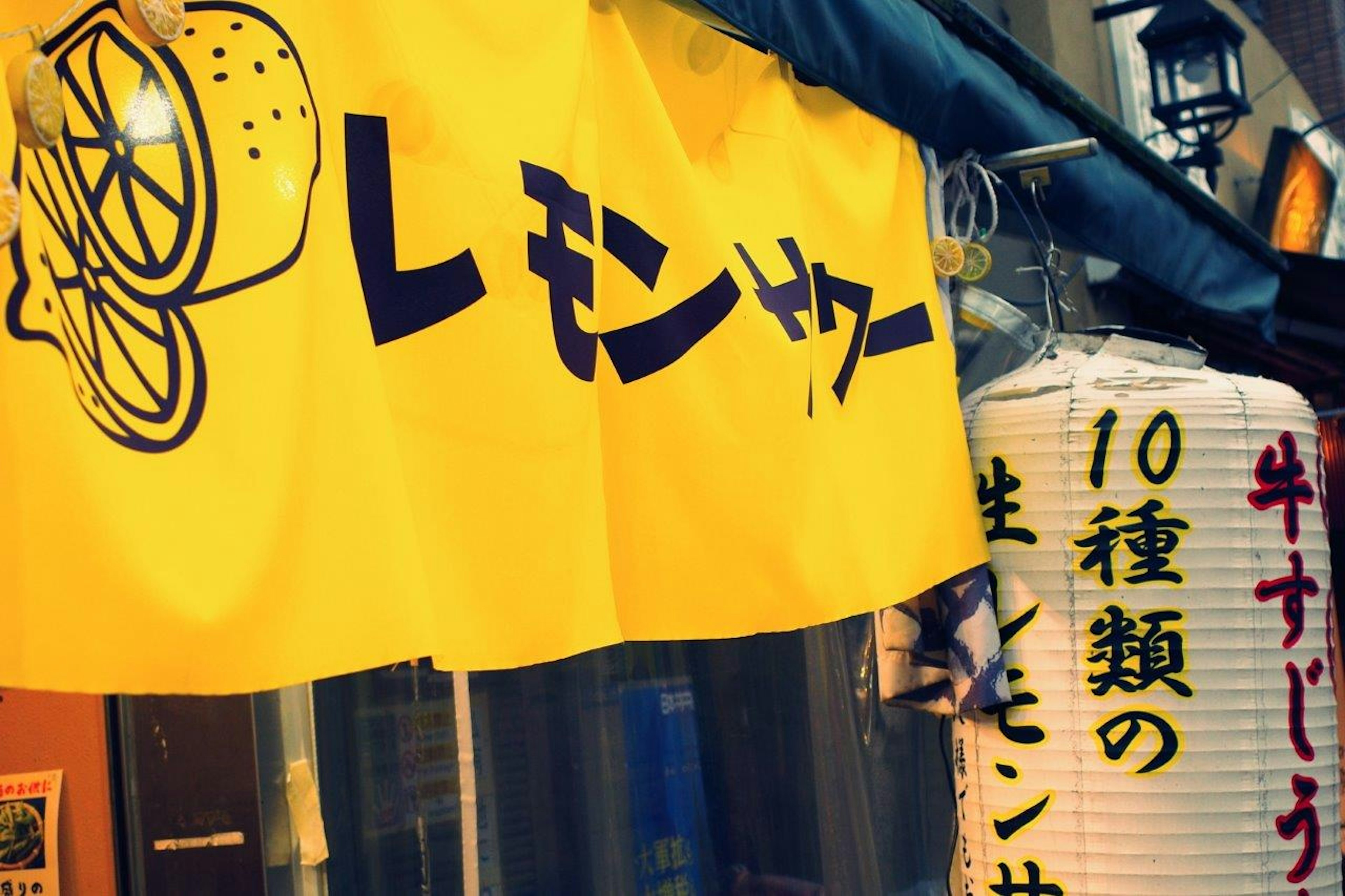 Rideau de magasin jaune avec une illustration de citron et du texte japonais