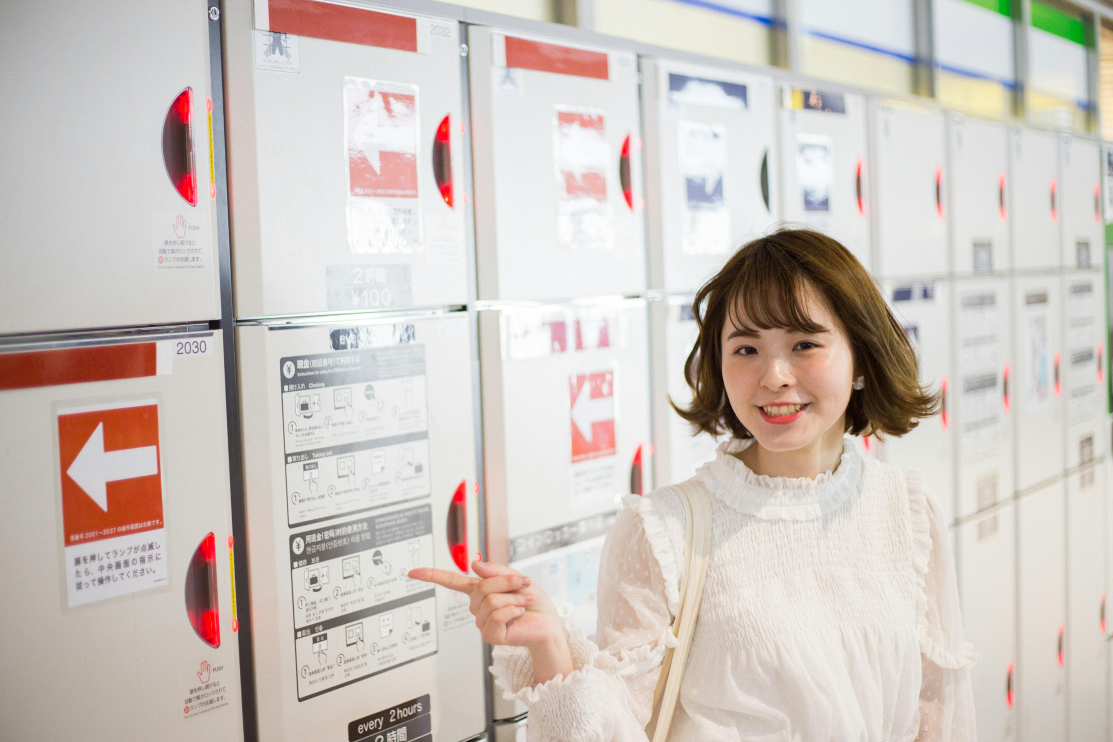 A woman pointing at lockers with a cheerful expression