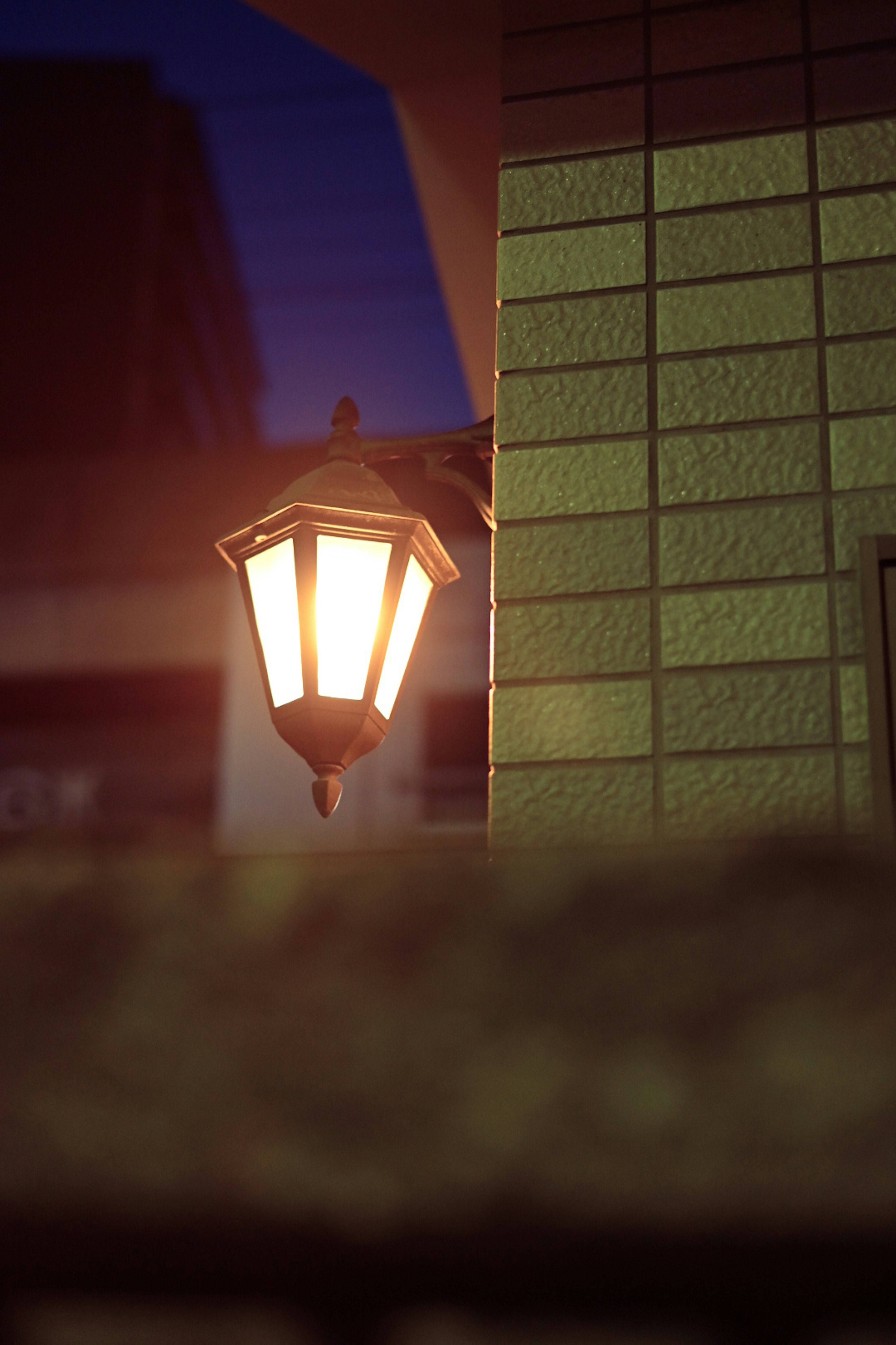 Foto di un lampione che emette una luce calda su un angolo di strada poco illuminato