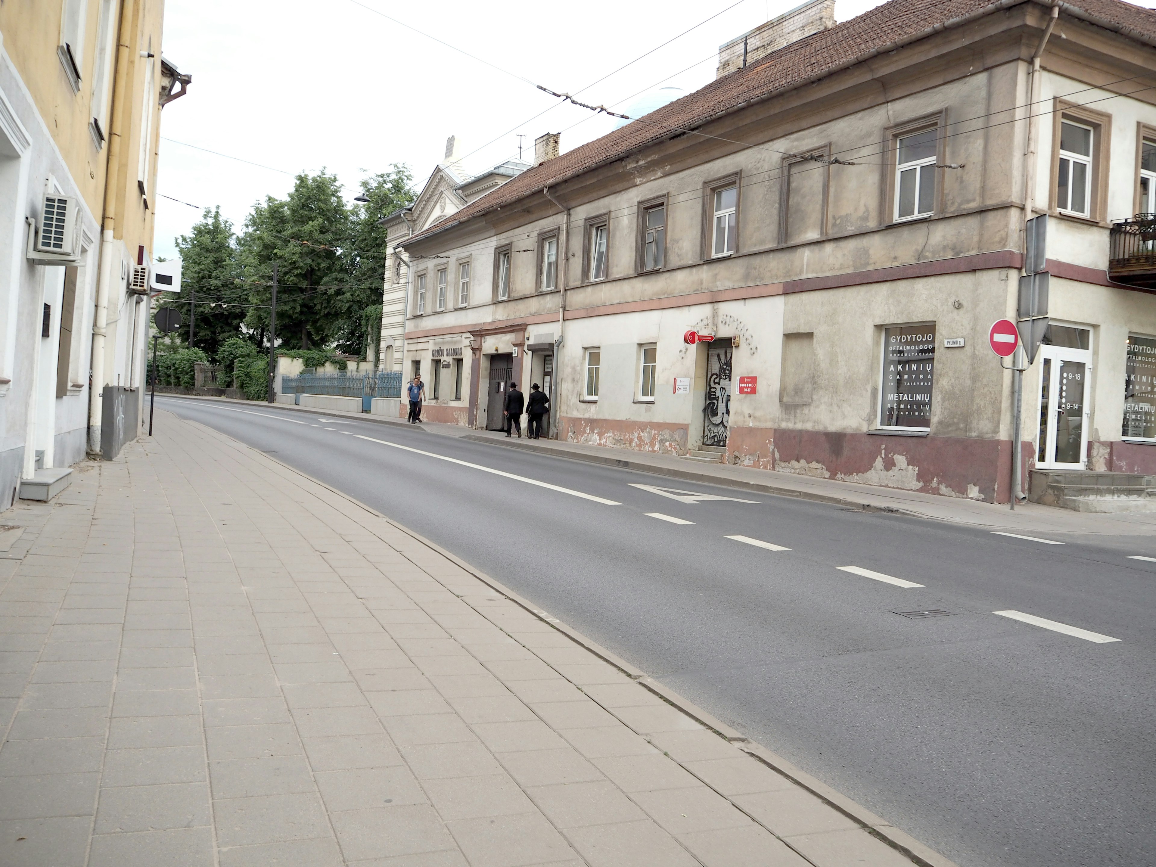 Vecchio edificio che si affaccia su una strada tranquilla con marciapiede pavimentato