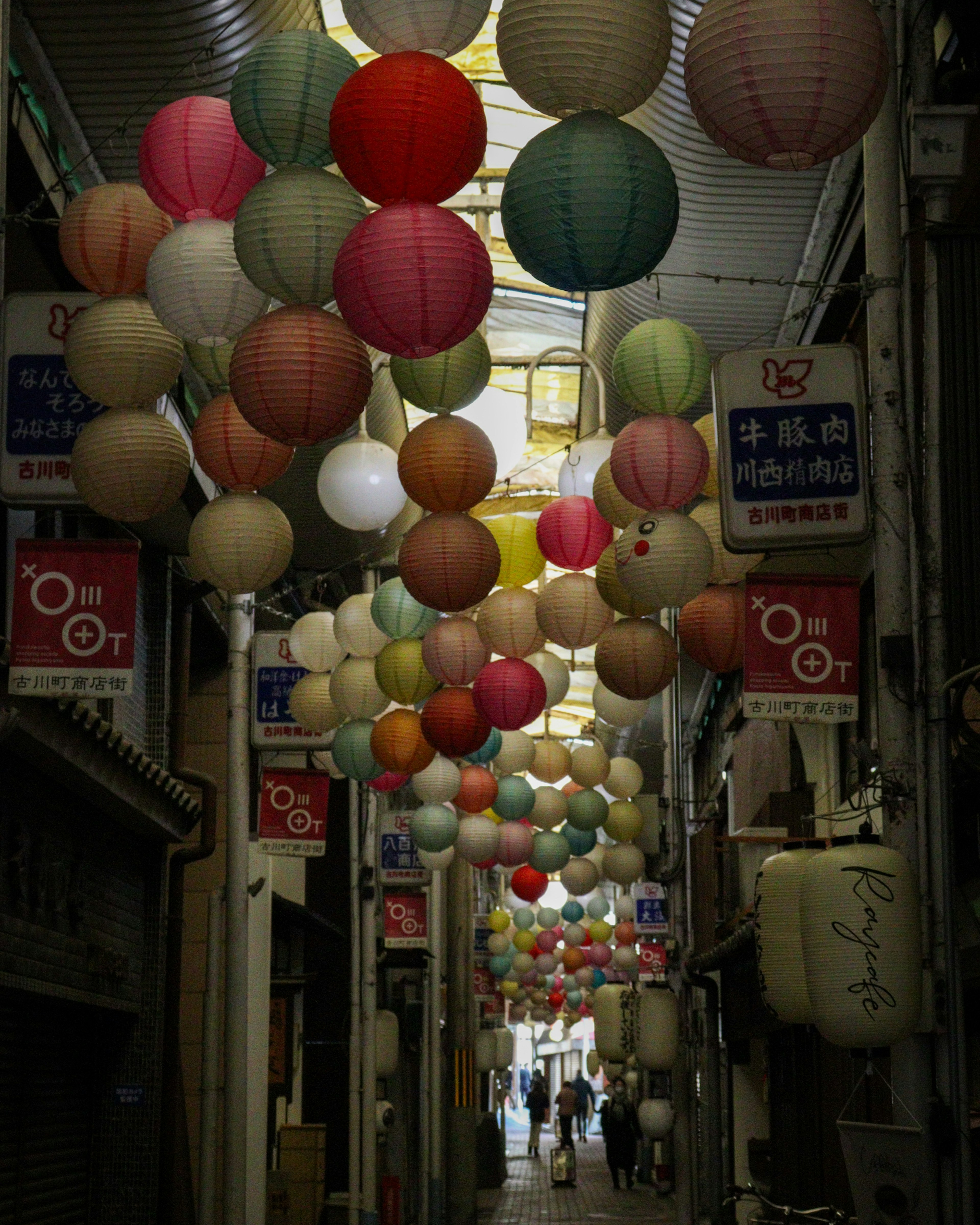 A street lined with colorful lanterns hanging overhead