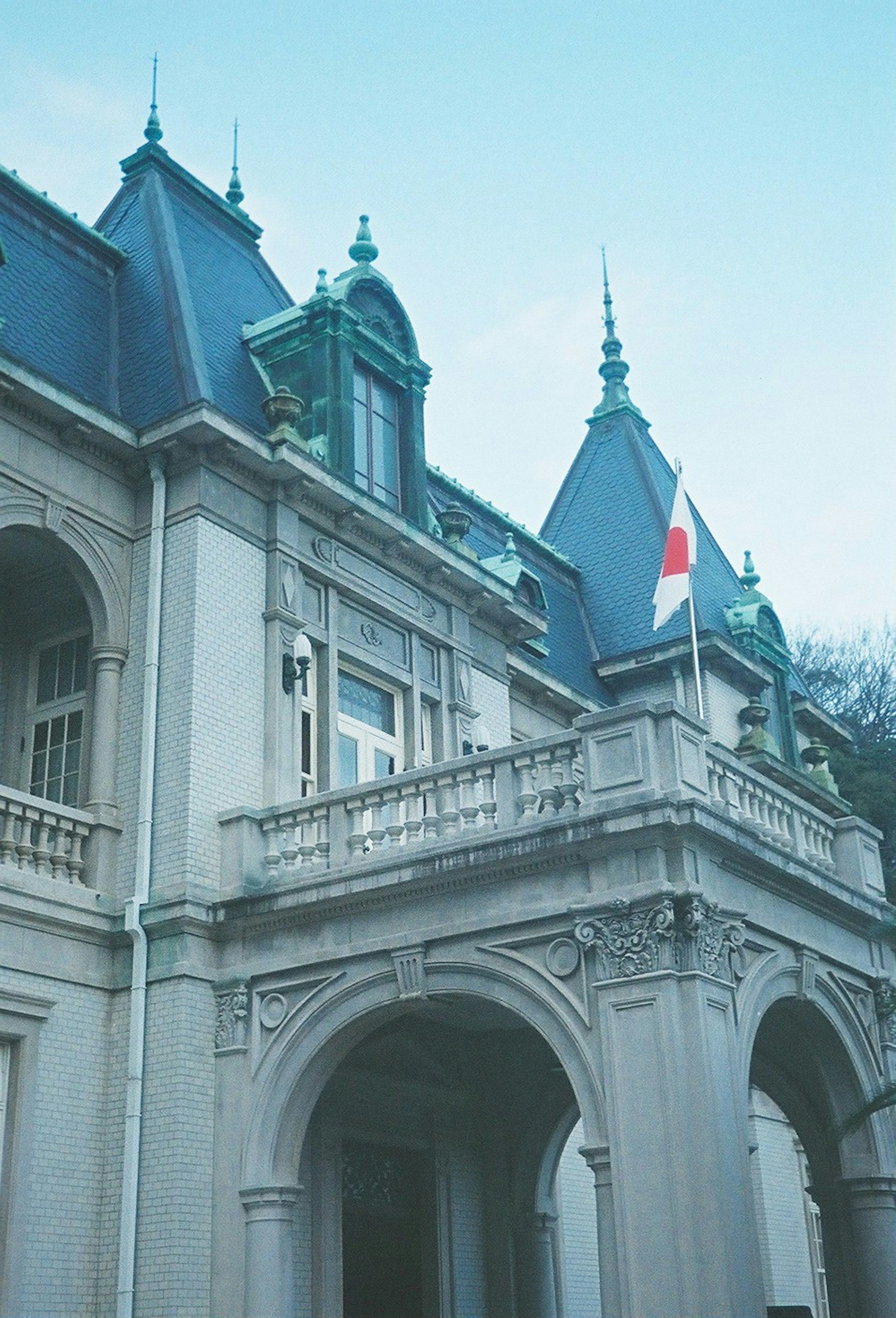 Historisches Gebäude mit spitzen Dächern und einer Nationalflagge