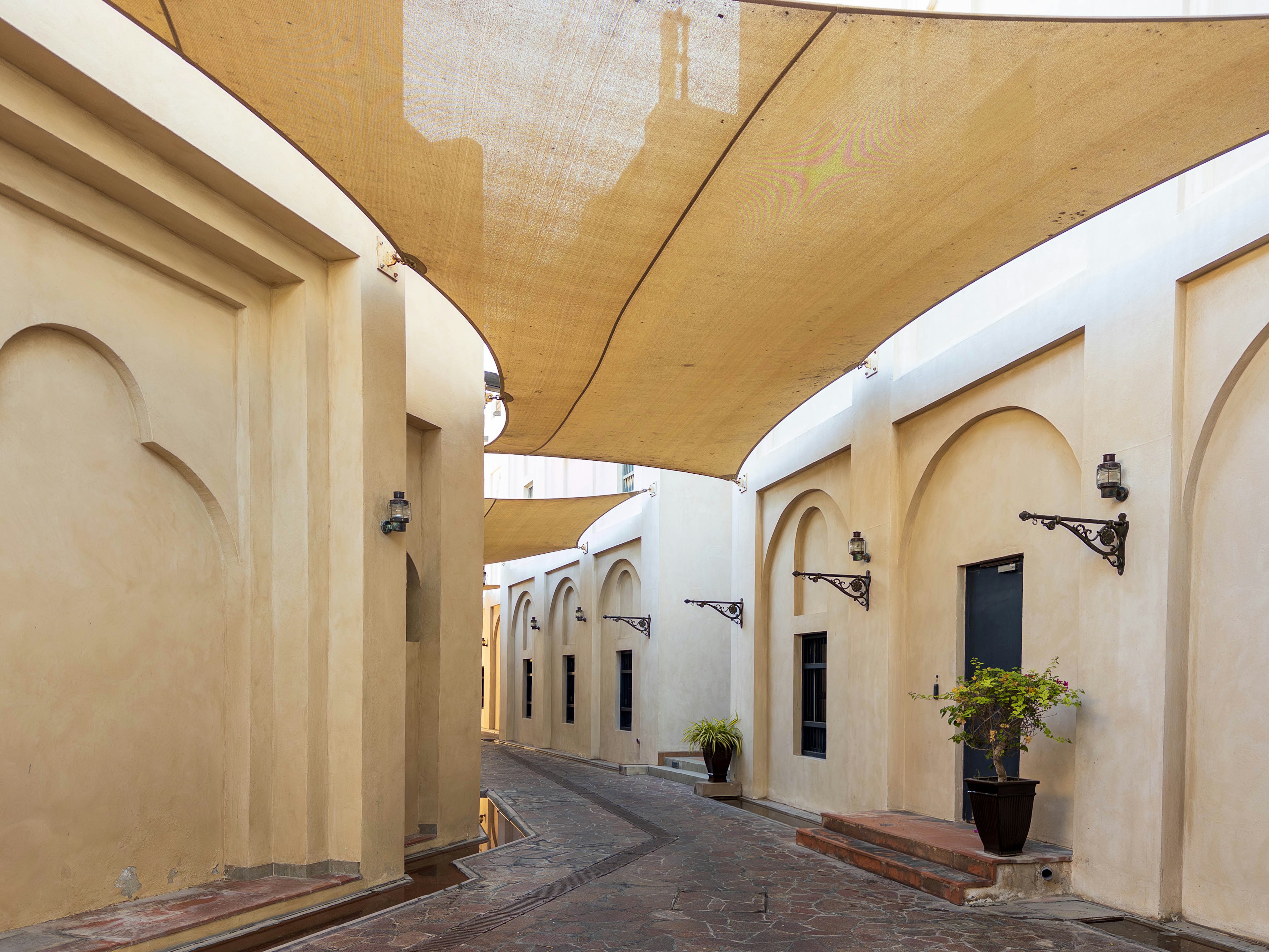 Calle estrecha con hermosas paredes arqueadas y un toldo