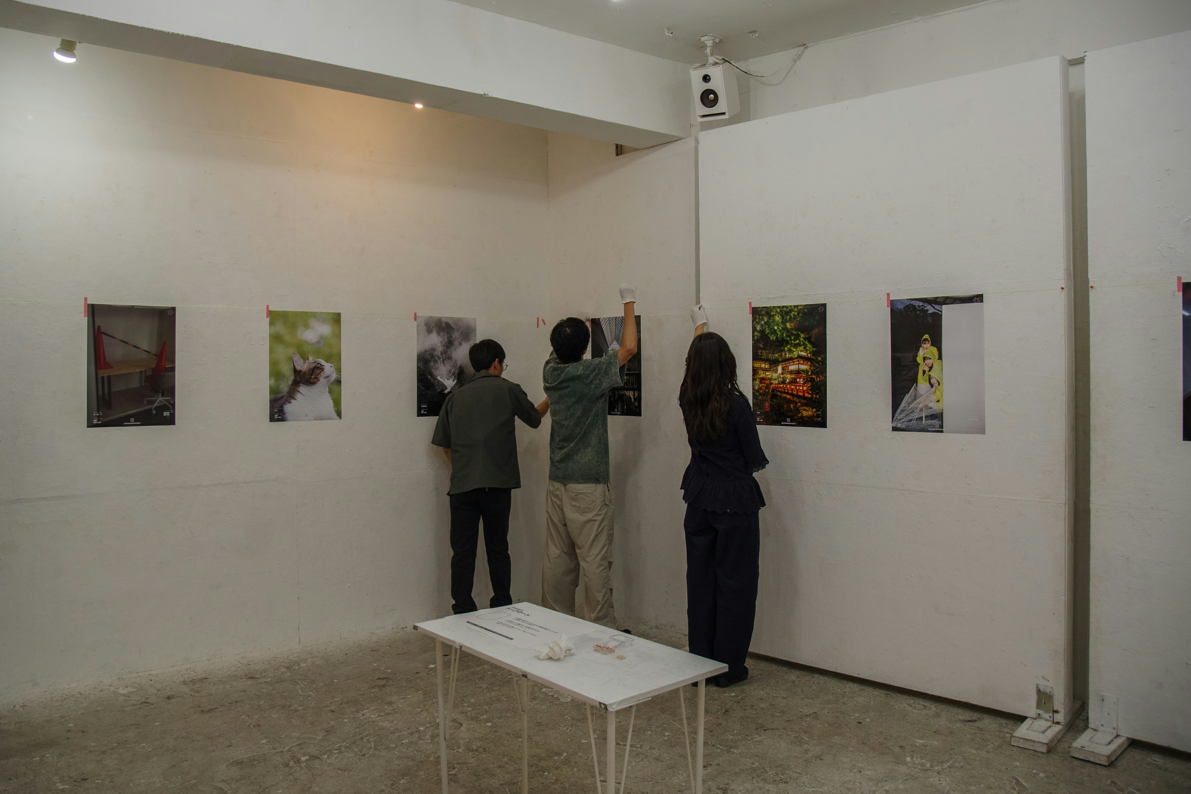 Menschen, die Kunstwerke in einer Galerie betrachten, mit Fotografien an den Wänden