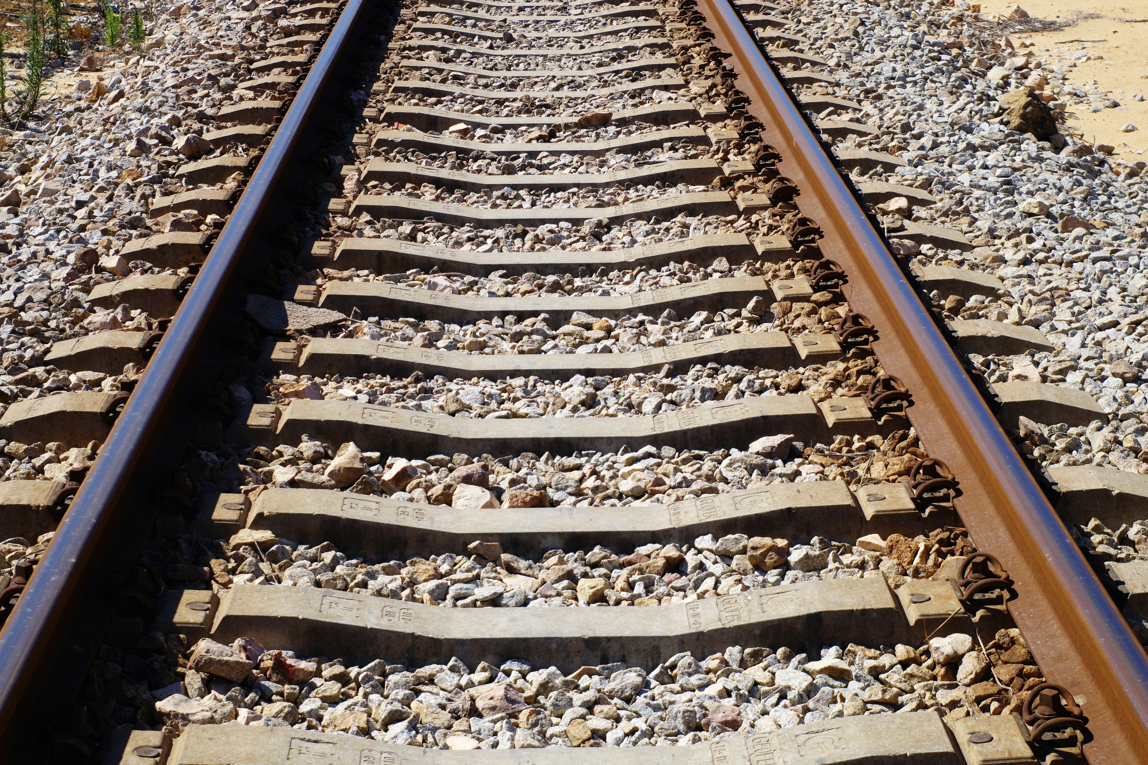 Primer plano de rieles de tren con grava y traviesas de madera