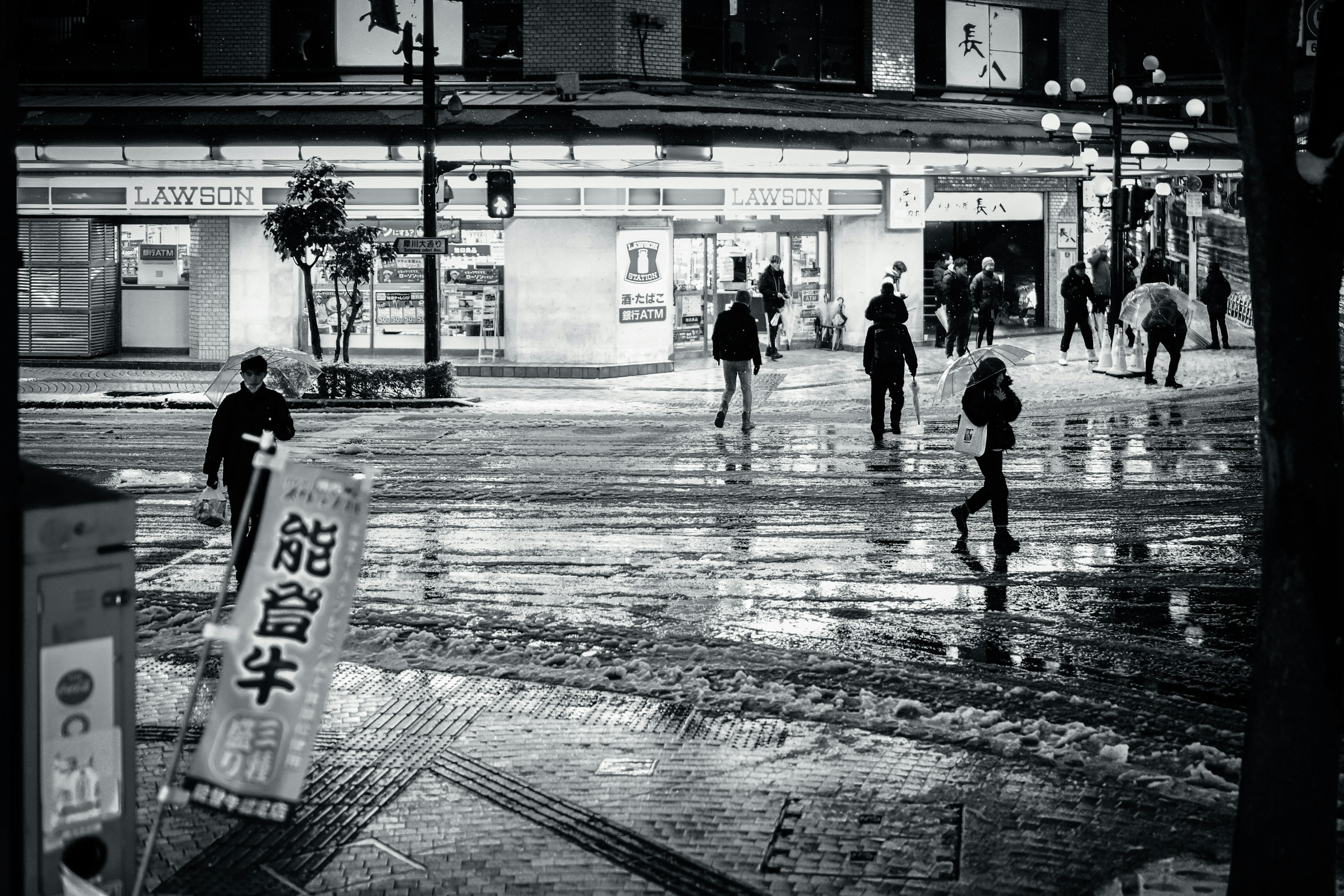 Night scene with pedestrians and wet pavement