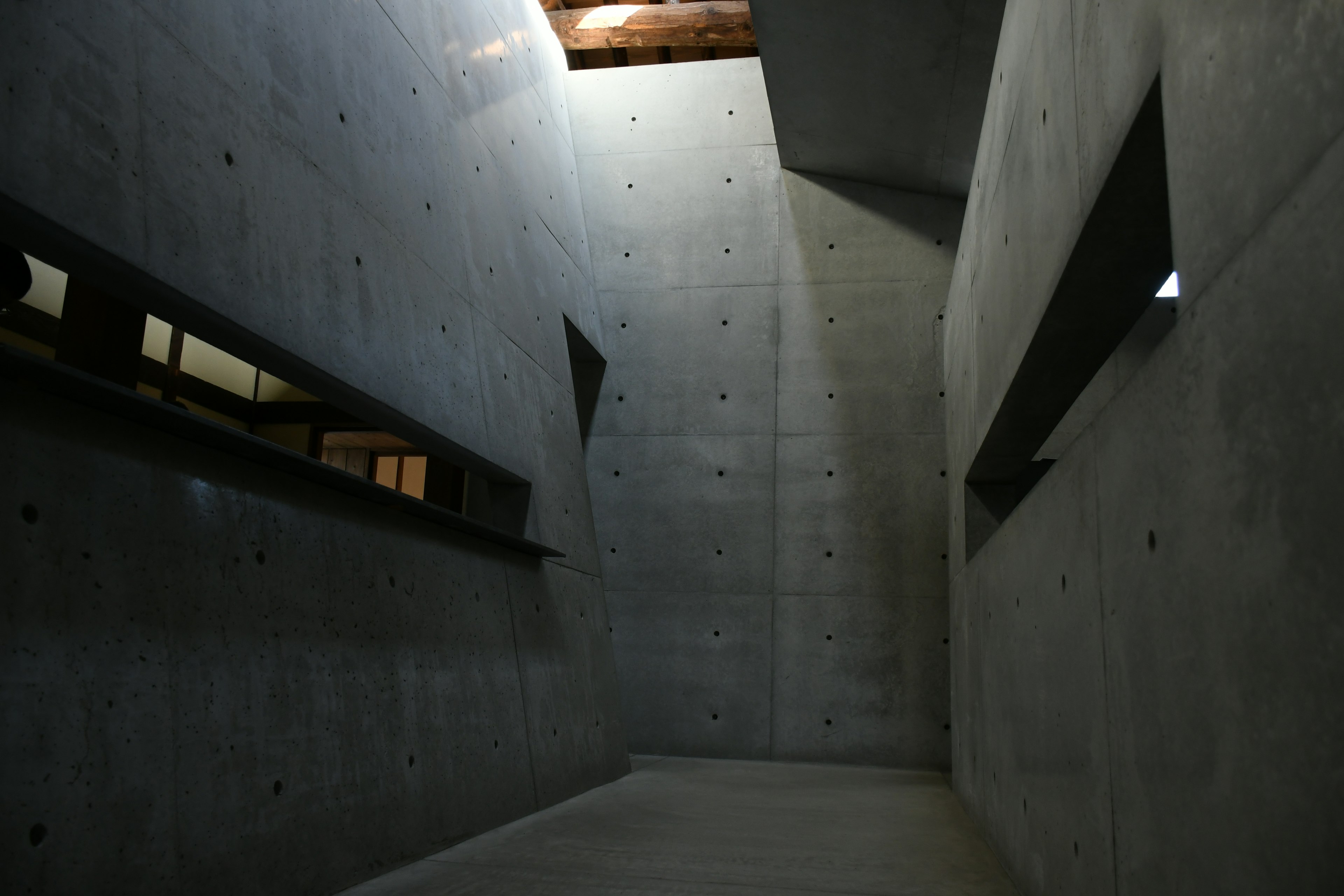 Espace intérieur d'un bâtiment moderne en béton Lumière brillante entrant par le haut Angles aigus et design linéaire