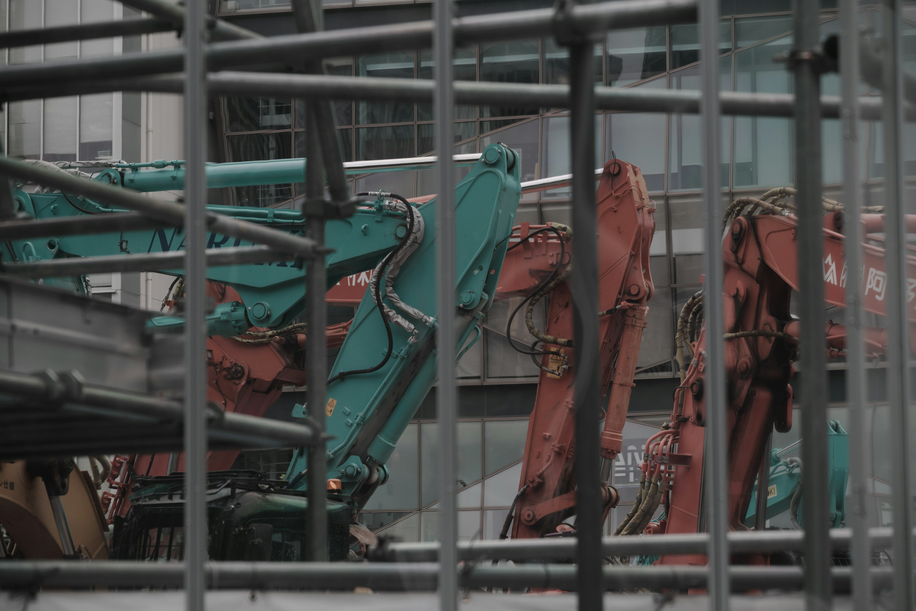 Image of construction site with visible crane arms in green and orange