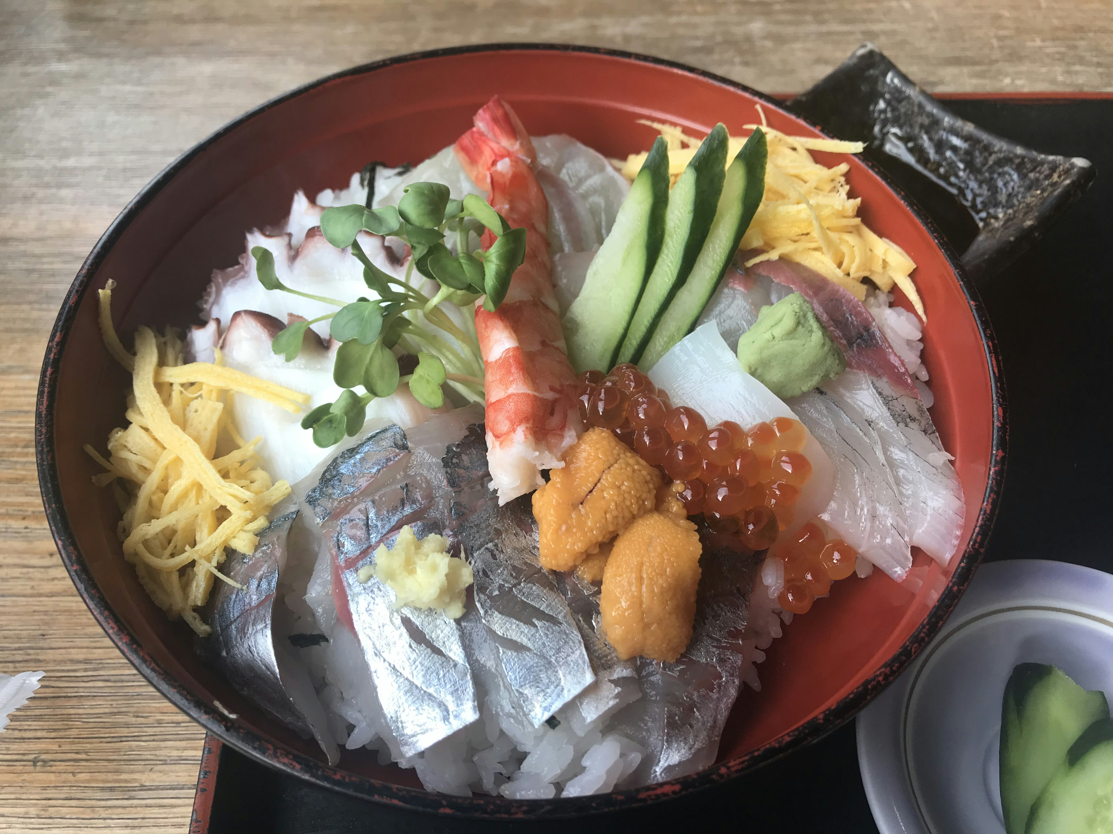 Una ciotola di riso di mare guarnita con sashimi colorato e decorazioni