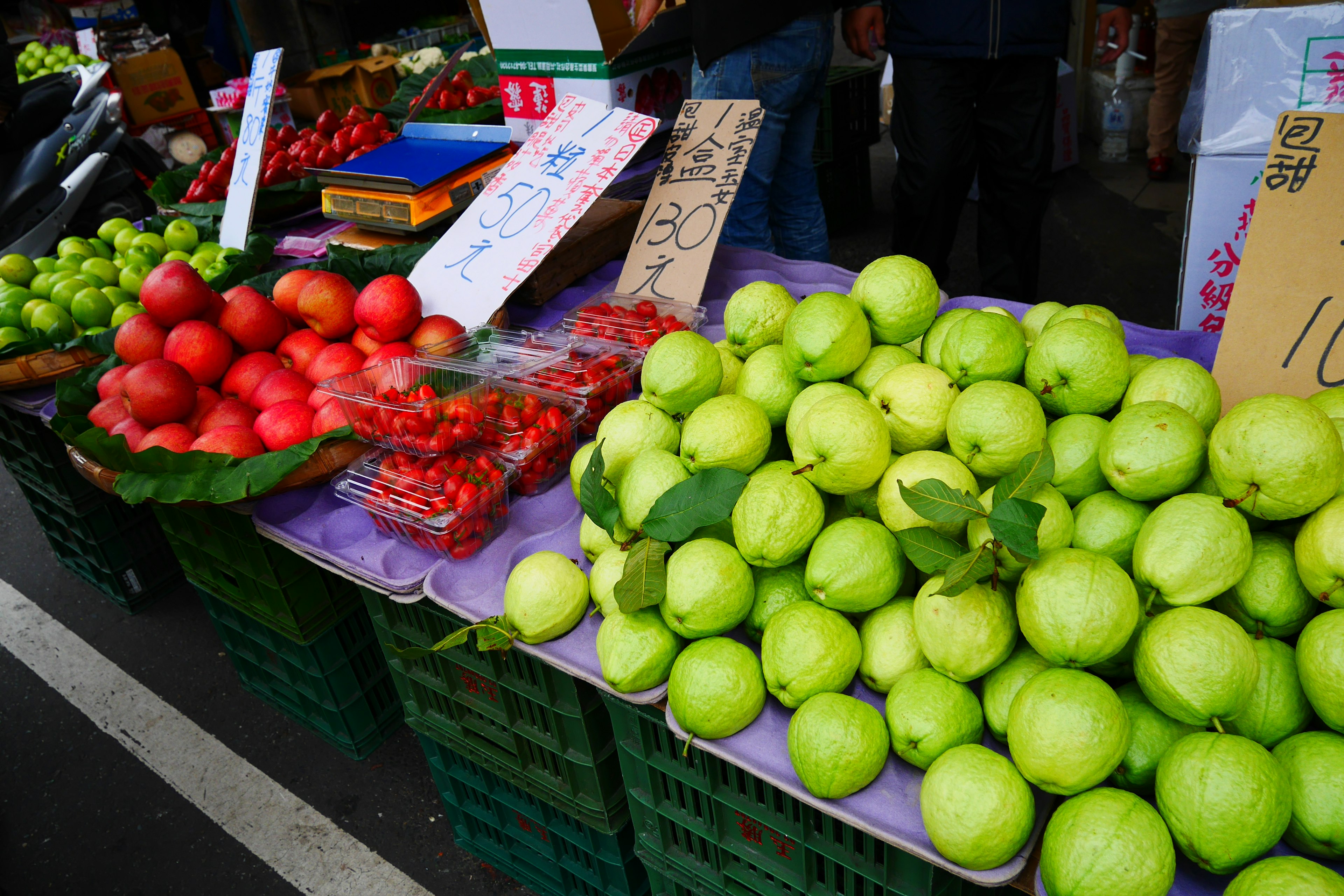 แผงผลไม้ที่ตลาดแสดงแอปเปิ้ลเขียวแอปเปิ้ลแดงและมะเขือเทศเชอร์รี่