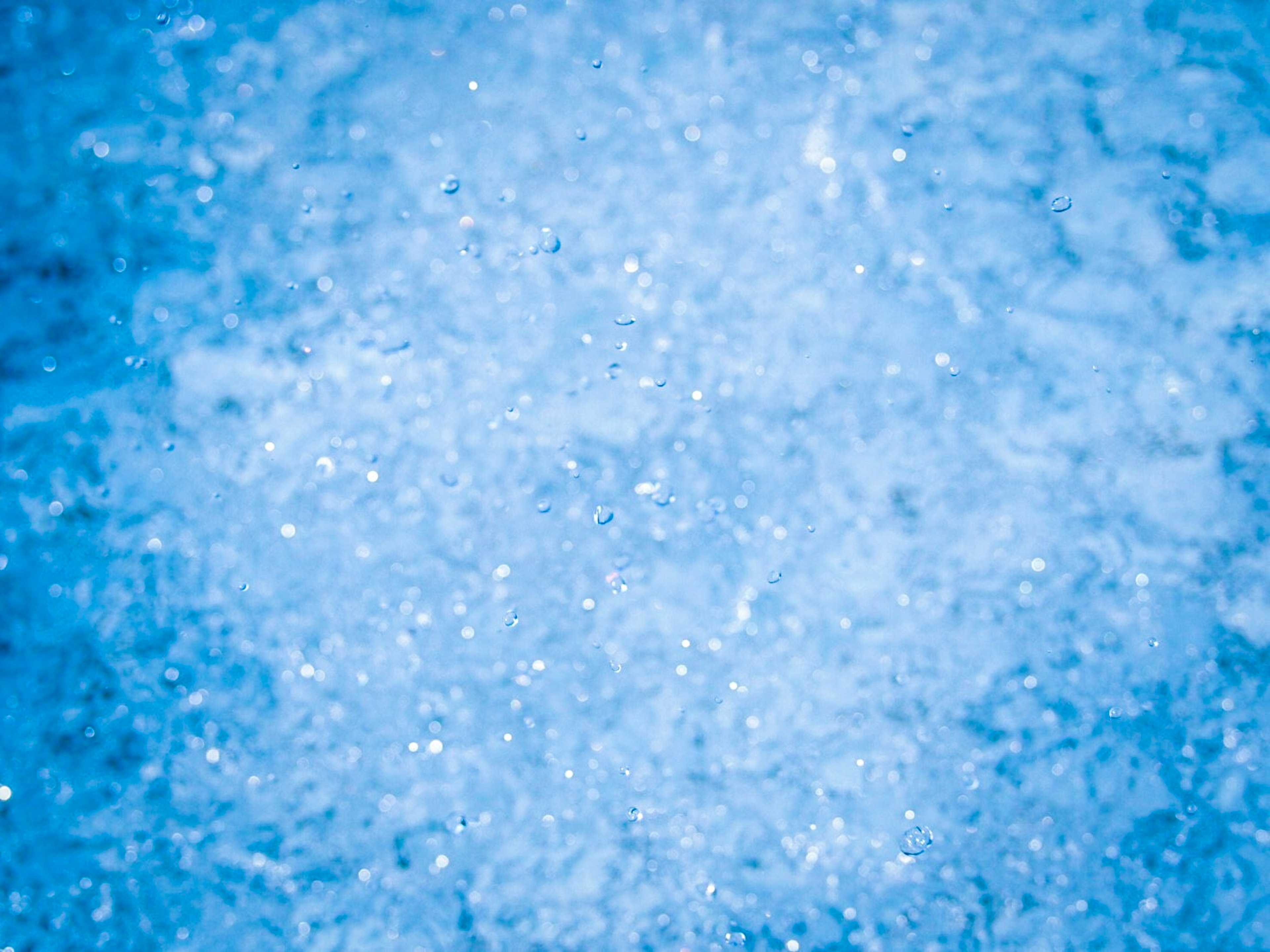 Éclaboussure d'eau bleue scintillante avec des gouttelettes brillantes