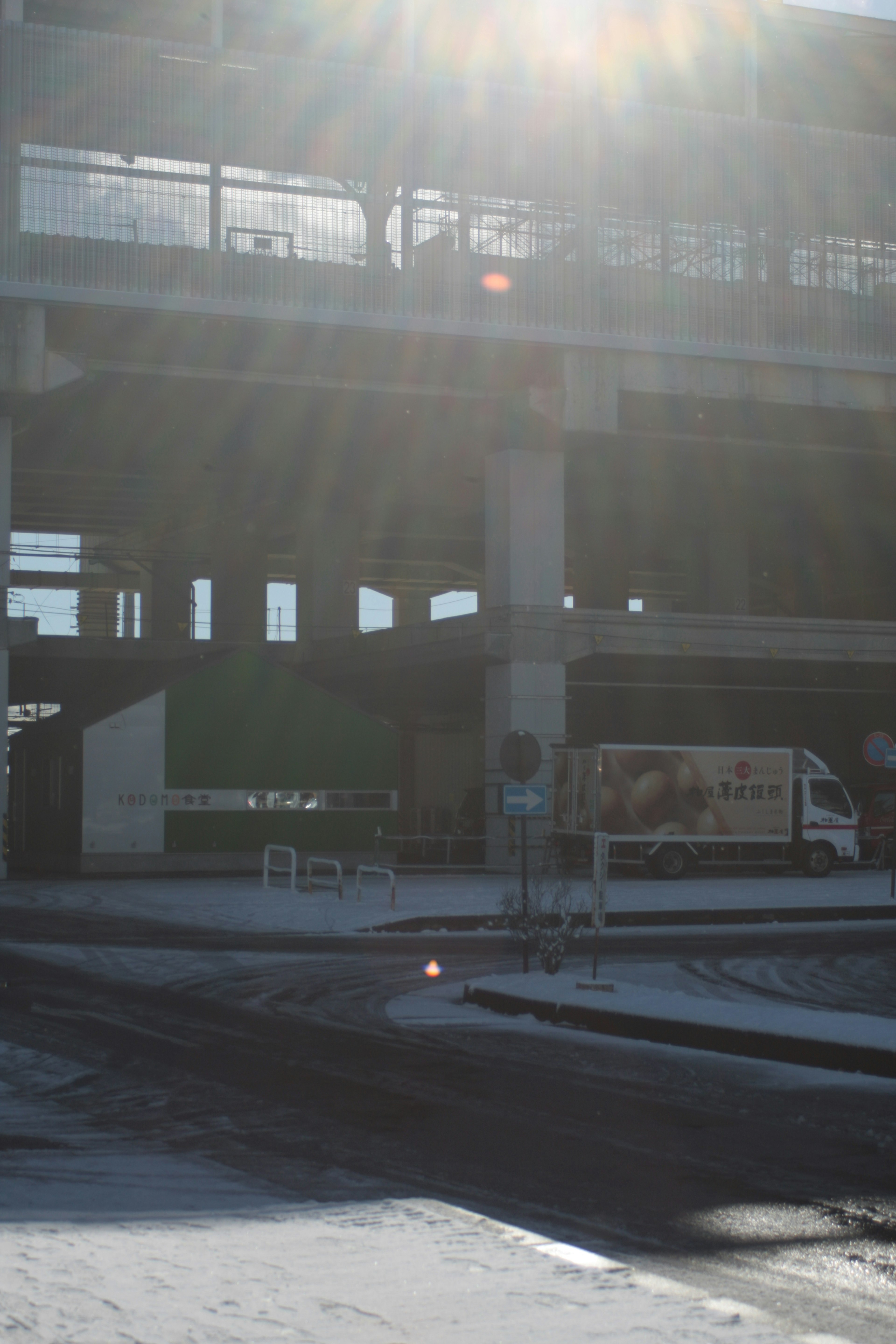 Urban landscape under bright sunlight featuring a road and a truck